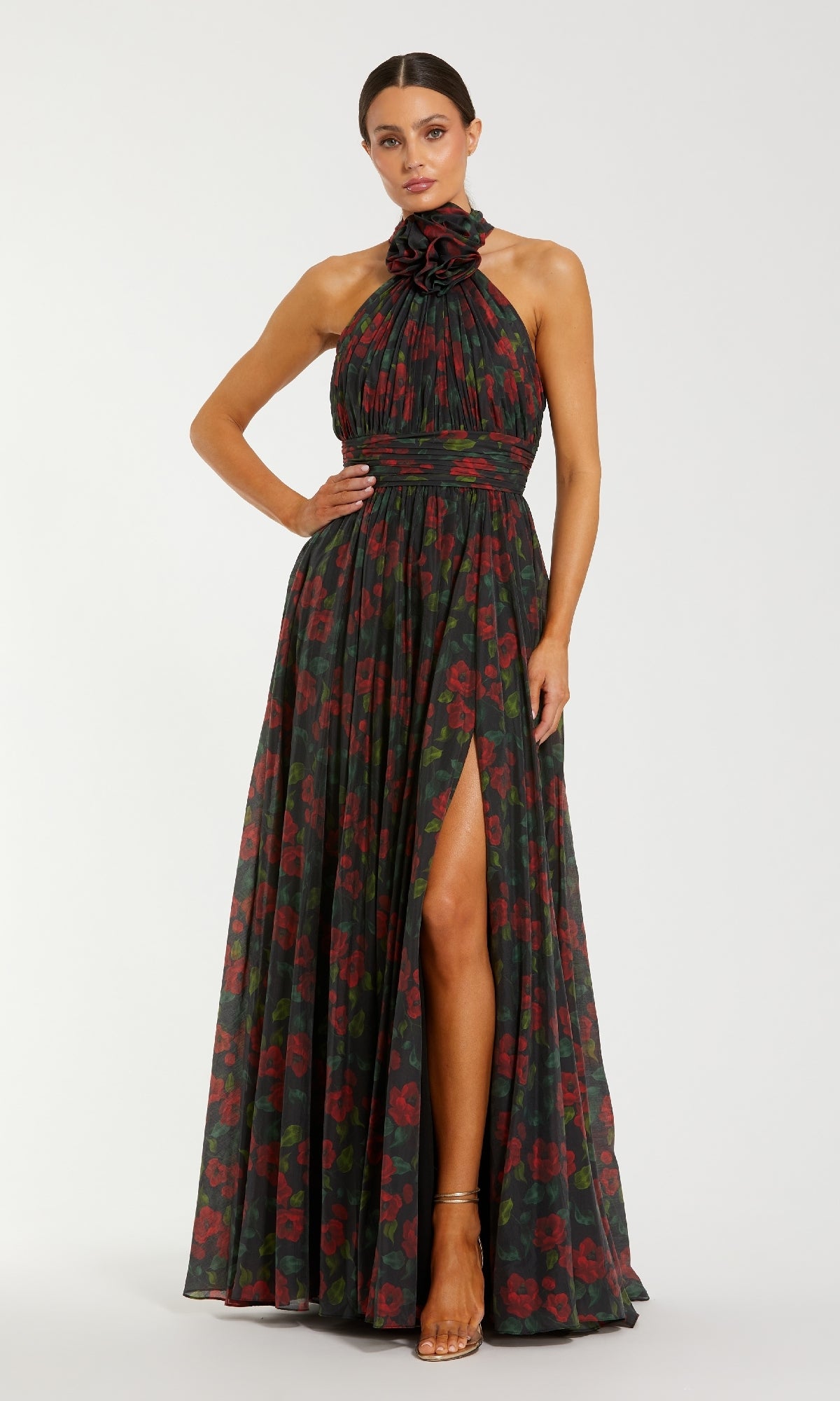 Woman wearing a floral halter neck gown with a high slit on a white background