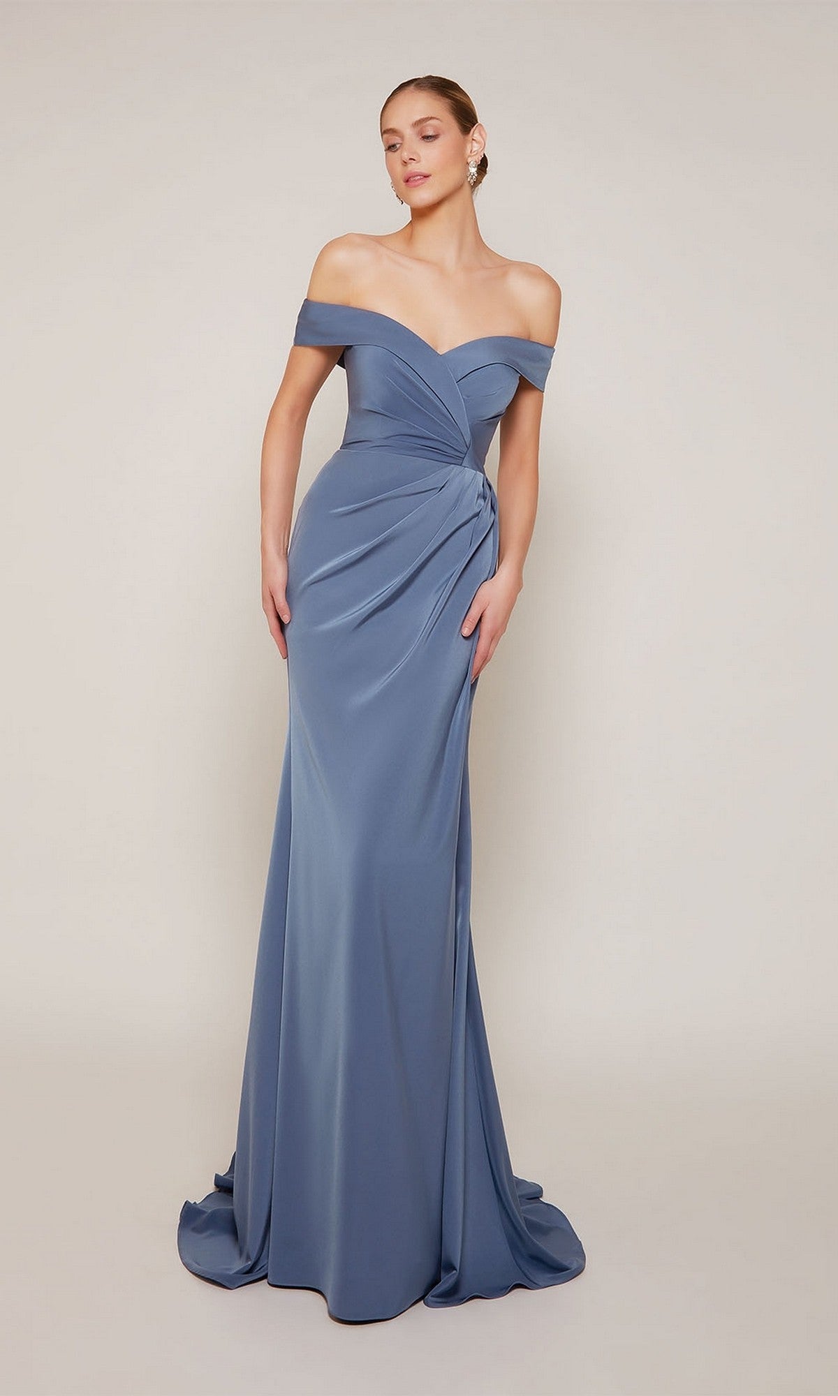 A woman poses against a plain light background in the Alyce 27698, a floor-length slate blue off-the-shoulder formal dress with draped detailing at the bodice and hip.