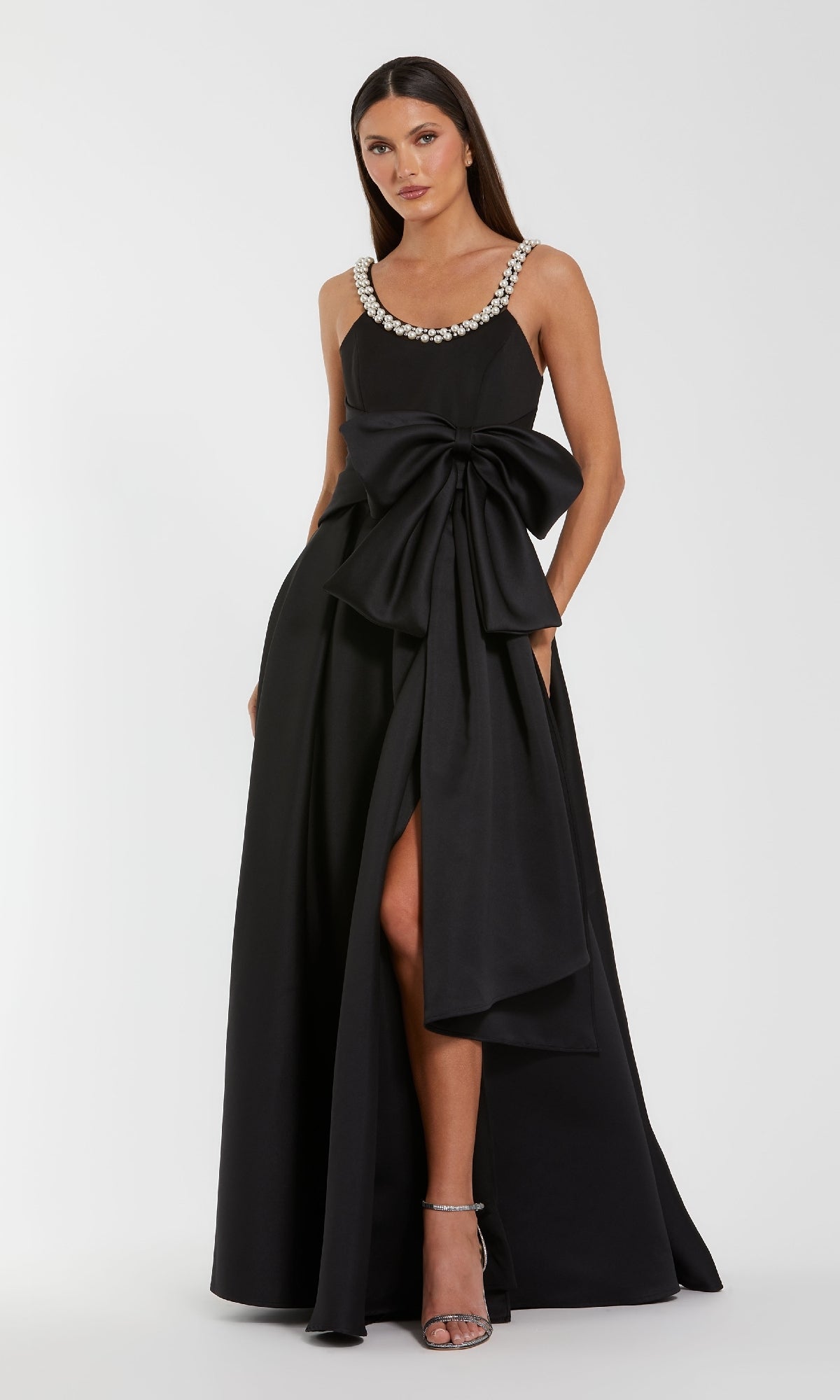 Black evening gown with a large bow and silver embellishments on a white background