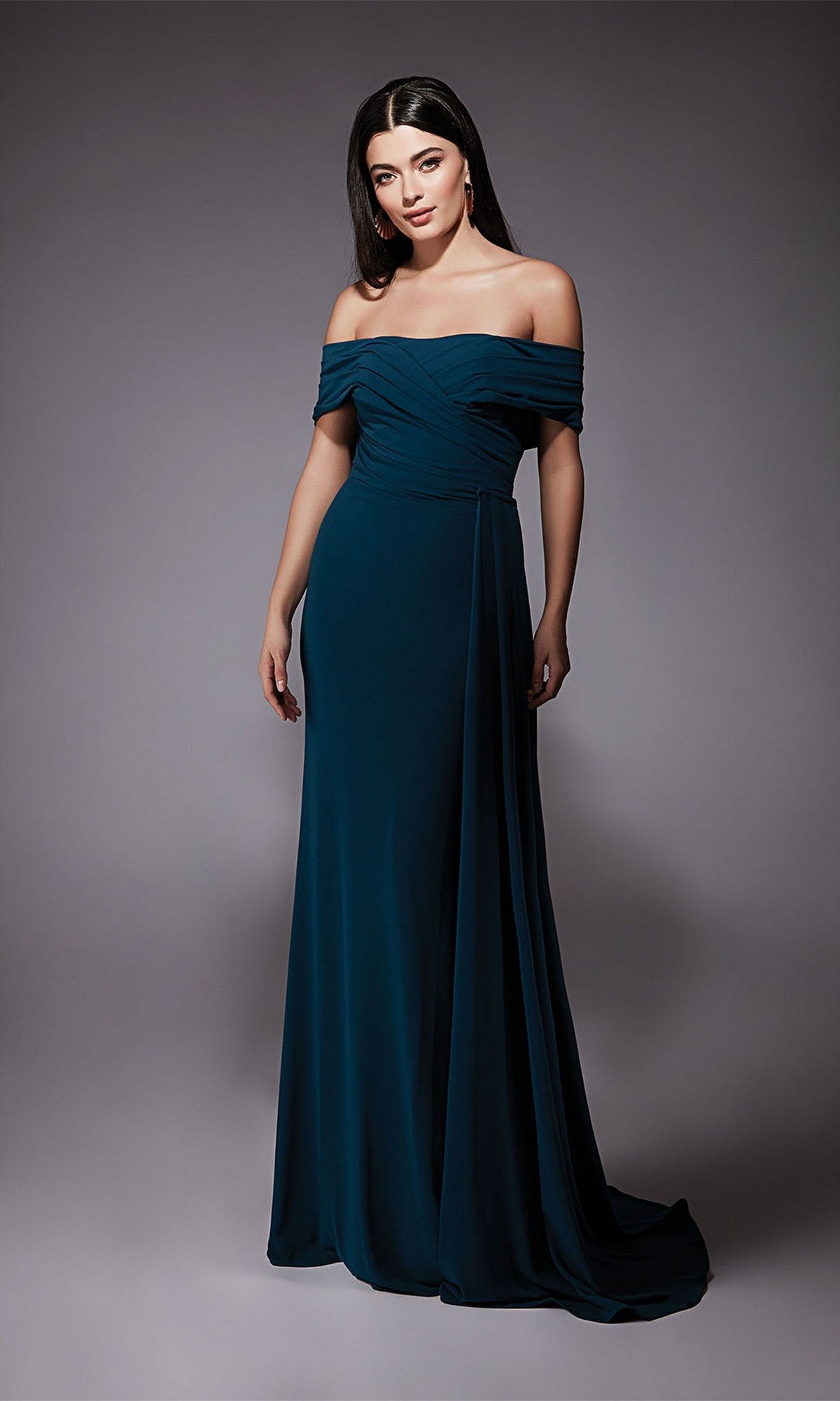 Woman wearing the Alyce 27745 long formal dress in midnight, off-the-shoulder and floor-length, standing against a plain gray background. Ideal for prom or any elegant occasion.