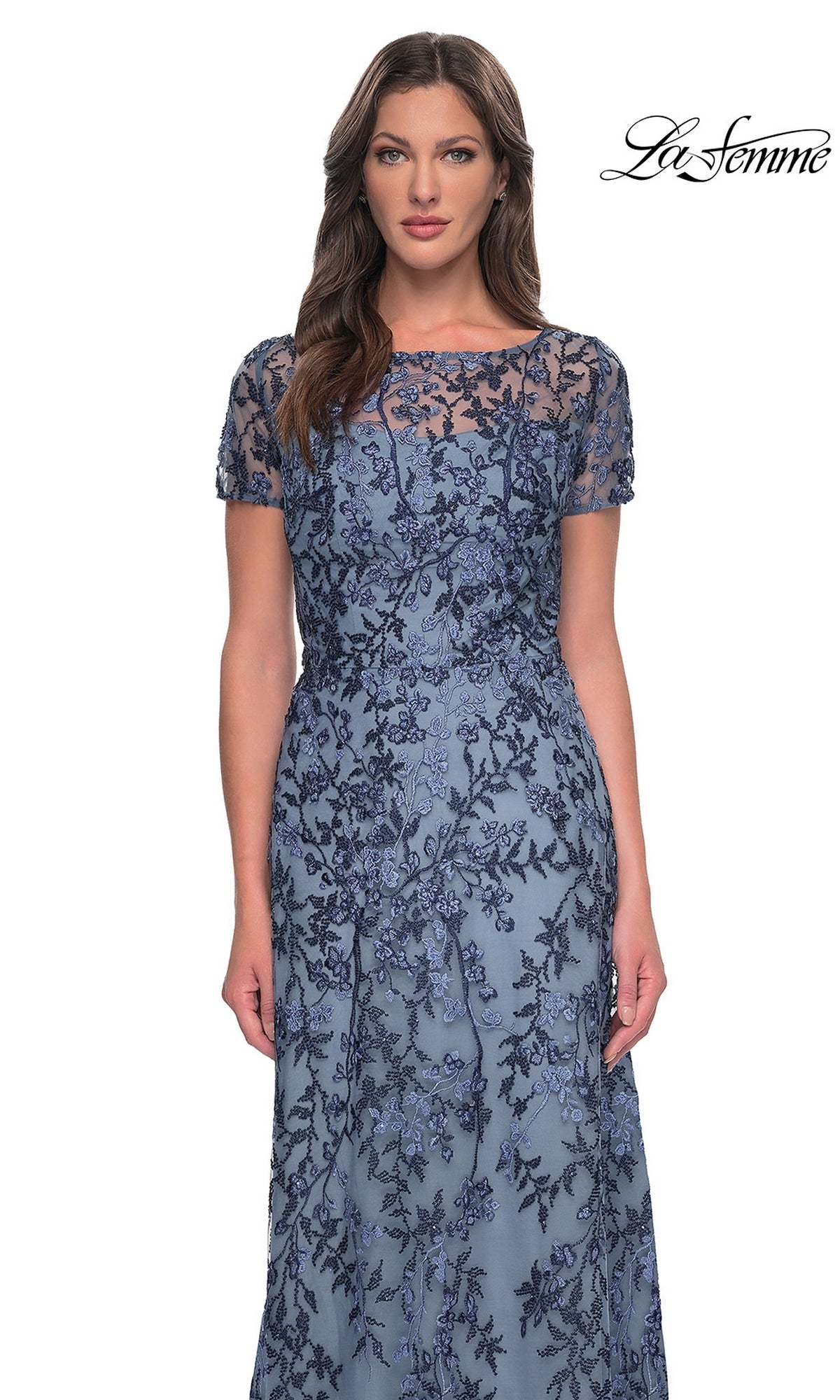 Woman wearing Long Formal Dress: La Femme 27956—blue, with floral lace overlay, short sleeves, and sheer neckline—stands against a white background.