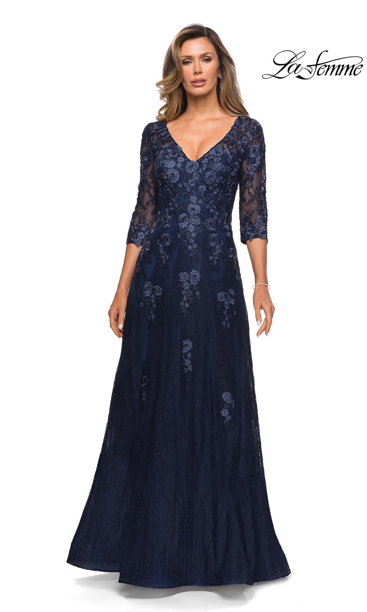Woman wearing Long Formal Dress: La Femme 28000 in navy, with floral lace, V-neckline, and three-quarter sleeves. “La Femme” logo in the top right corner.