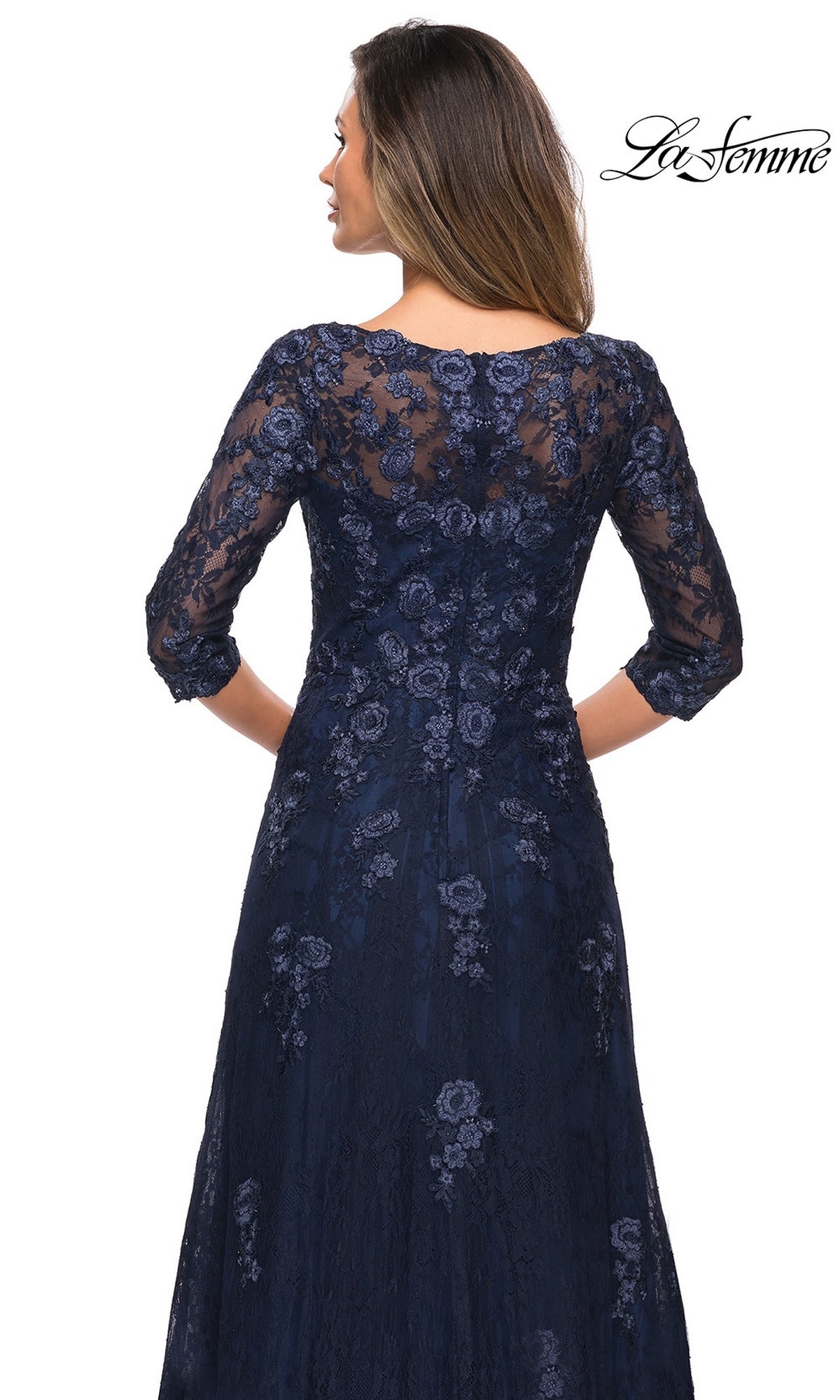 Woman facing away in a navy Long Formal Dress: La Femme 28000 with floral lace, three-quarter sleeves; “La Femme” logo top right.