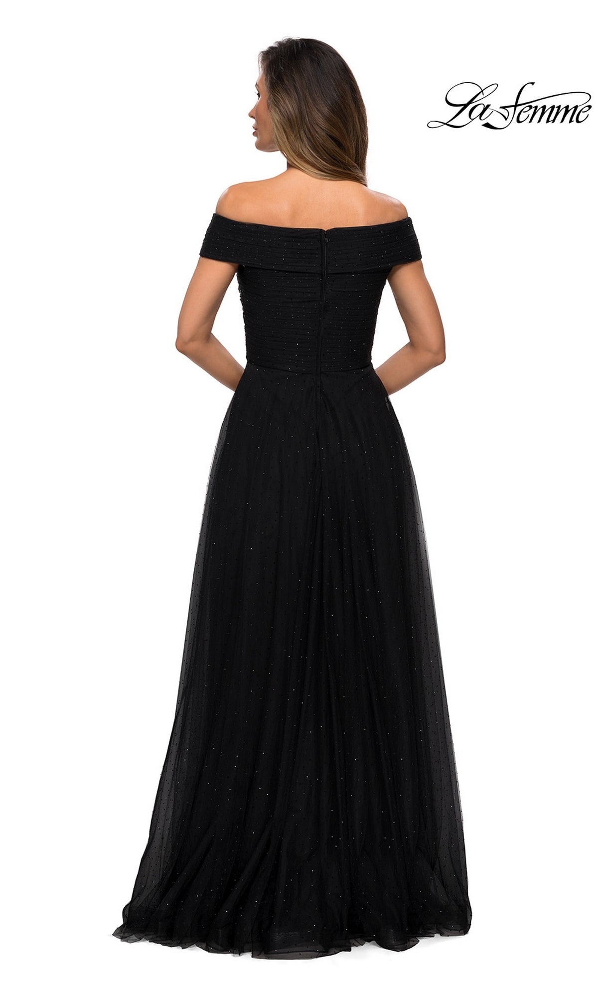Woman wearing Long Formal Dress: La Femme 28051, a black, off-the-shoulder glitter gown with an elegant A-line silhouette, stands facing away against a white background.