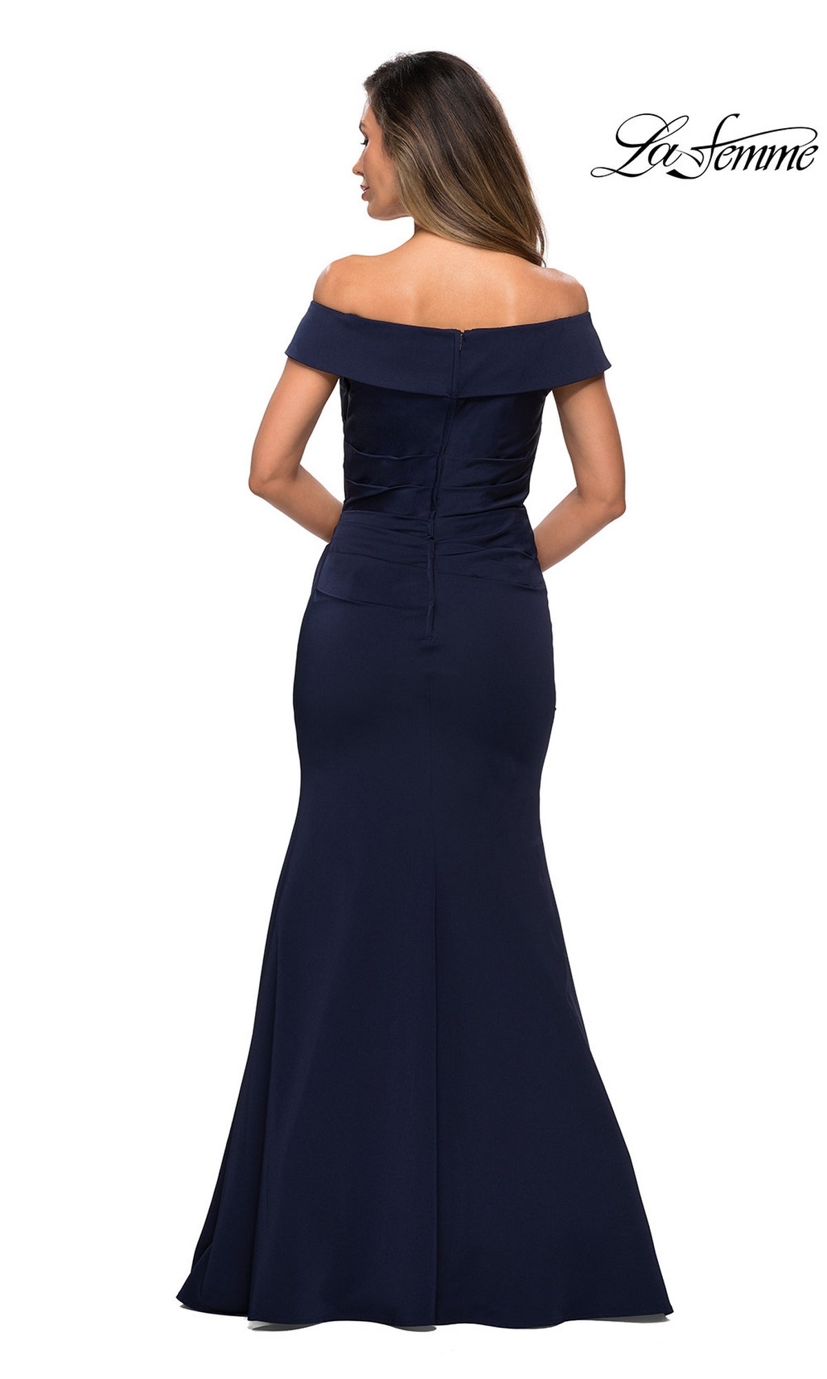 Woman models the Long Formal Dress: La Femme 28110, a navy blue satin off-the-shoulder gown with a fitted bodice and flared trumpet skirt, facing away for an elegant look.