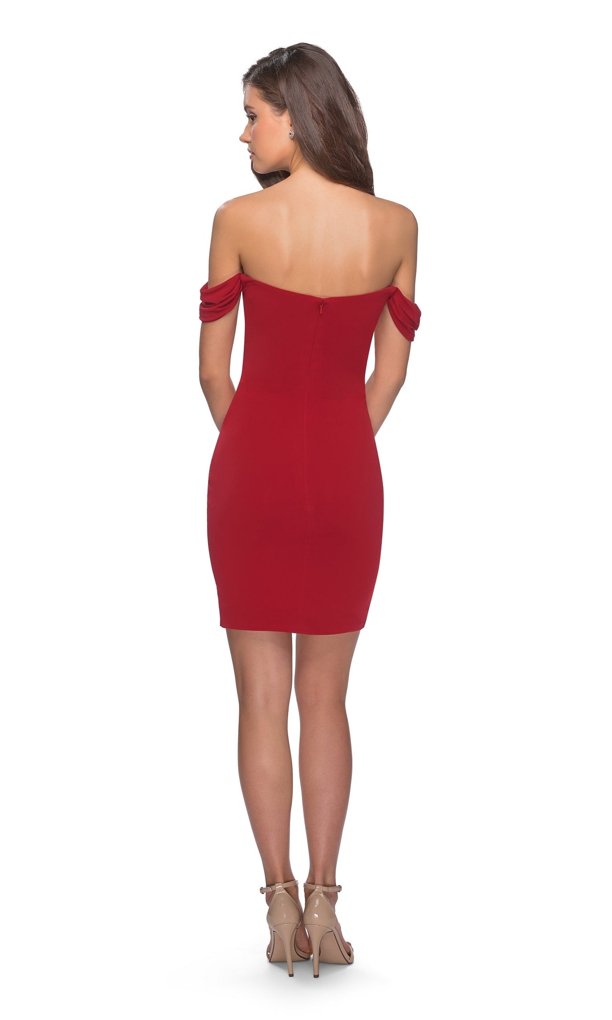 A woman stands with her back to the camera, wearing the La Femme Off-Shoulder Short Homecoming Dress 28193, featuring a fitted silhouette and paired with nude high-heeled sandals against a white background.