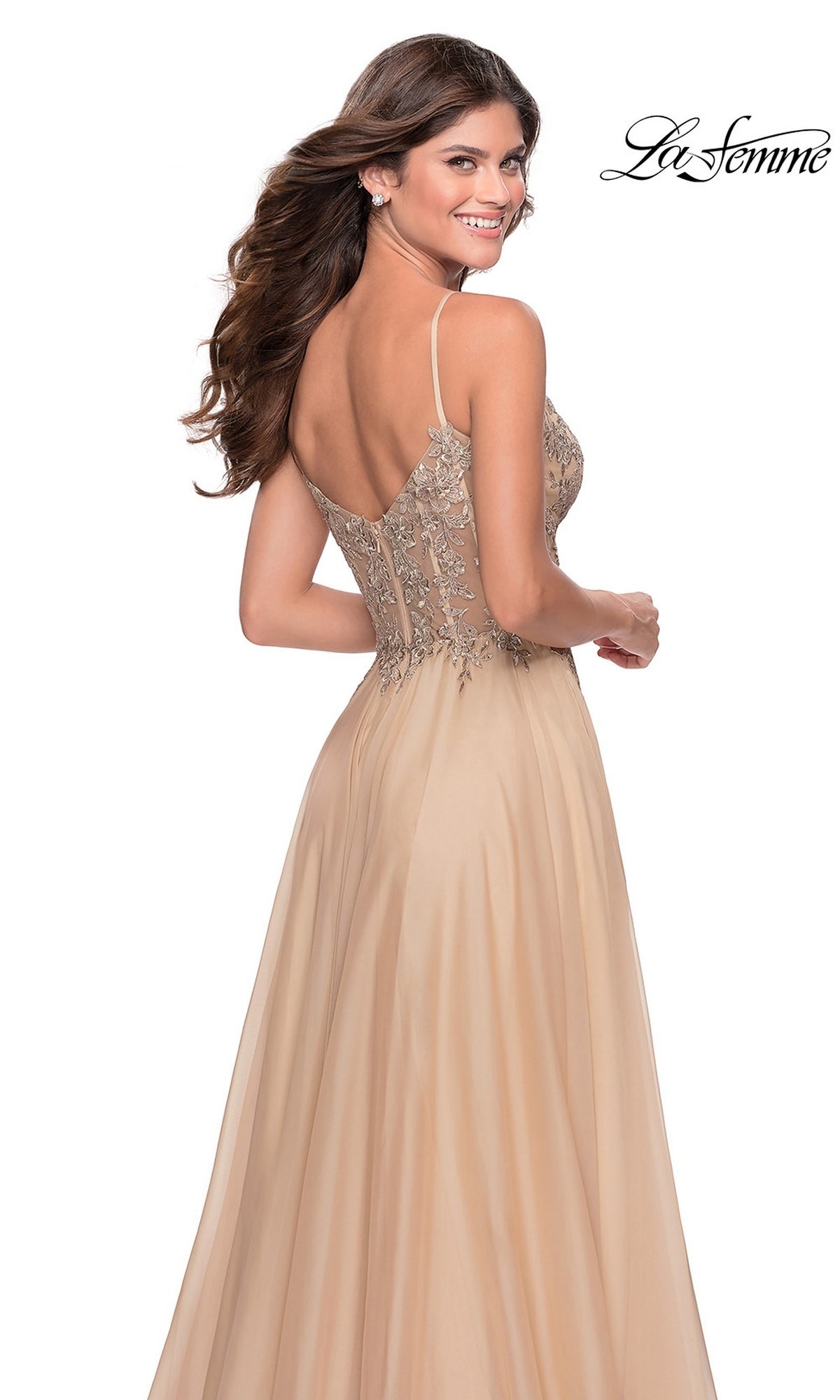 A woman wearing a tan floor-length chiffon Long Prom Dress: La Femme 28543 with thin straps and a lace bodice.