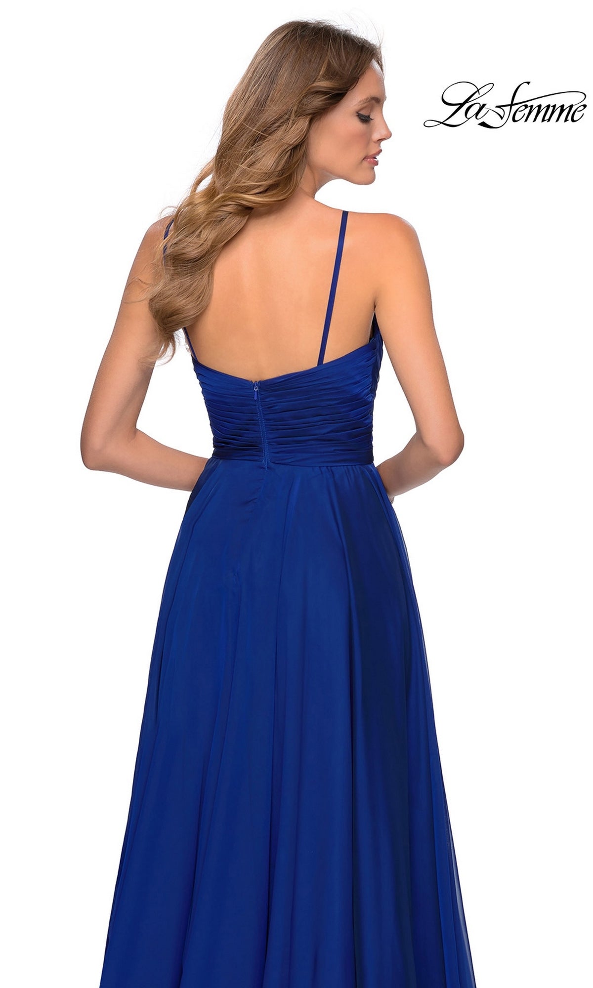 Back view of a woman in a royal blue La Femme 28611 A-line chiffon prom dress with a pleated bodice, thin straps, and a floor-length skirt.