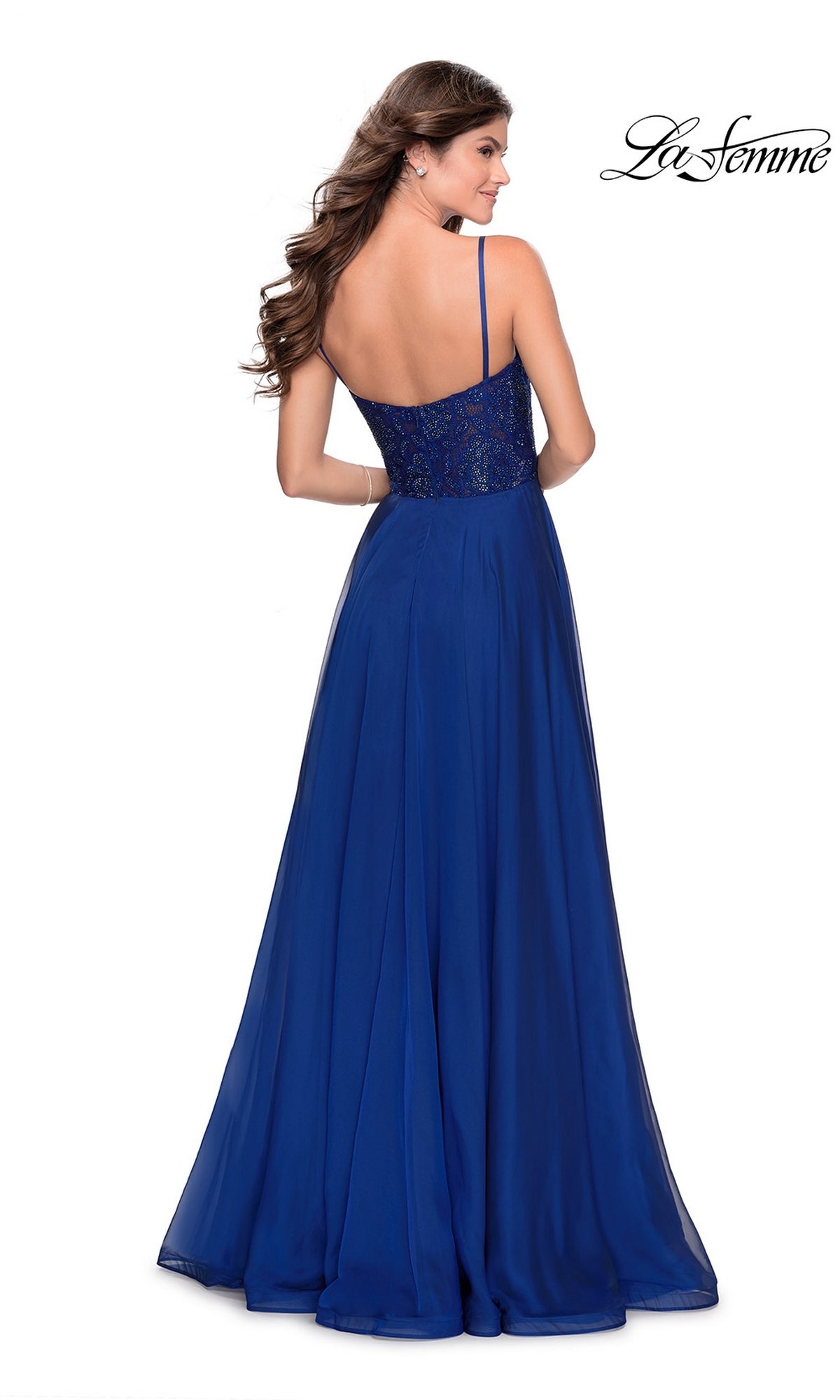 A woman faces away in the La Femme Sheer-Lace-Bodice Long Prom Dress 28664, a royal blue, floor-length A-line gown with thin straps and an embroidered lace bodice. The La Femme logo appears in the top right corner.