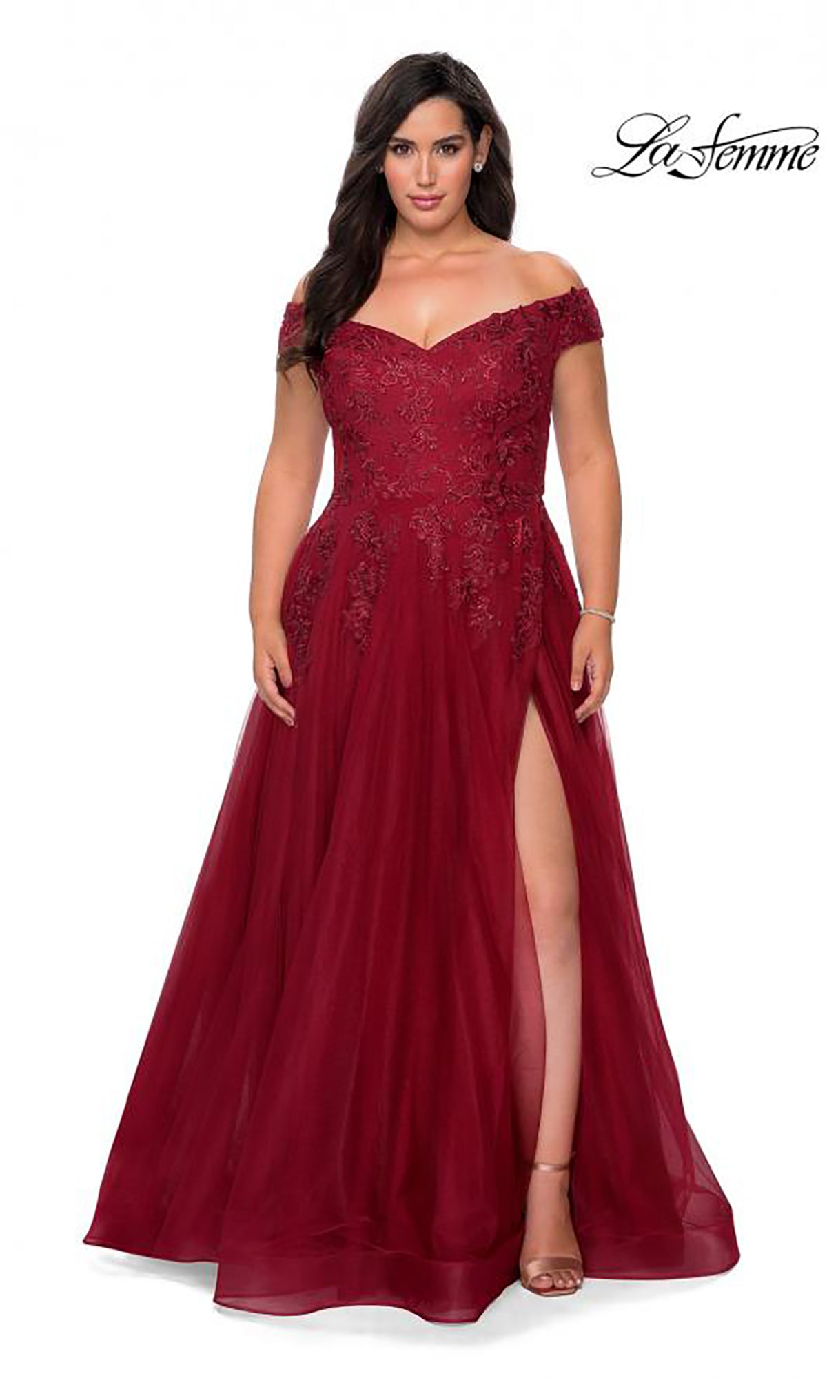 A woman wearing the Off-the-Shoulder Plus-Size La Femme Prom Ball Gown in burgundy, featuring floral beaded embroidery, a fitted bodice, and a thigh-high slit, stands against a white background.
