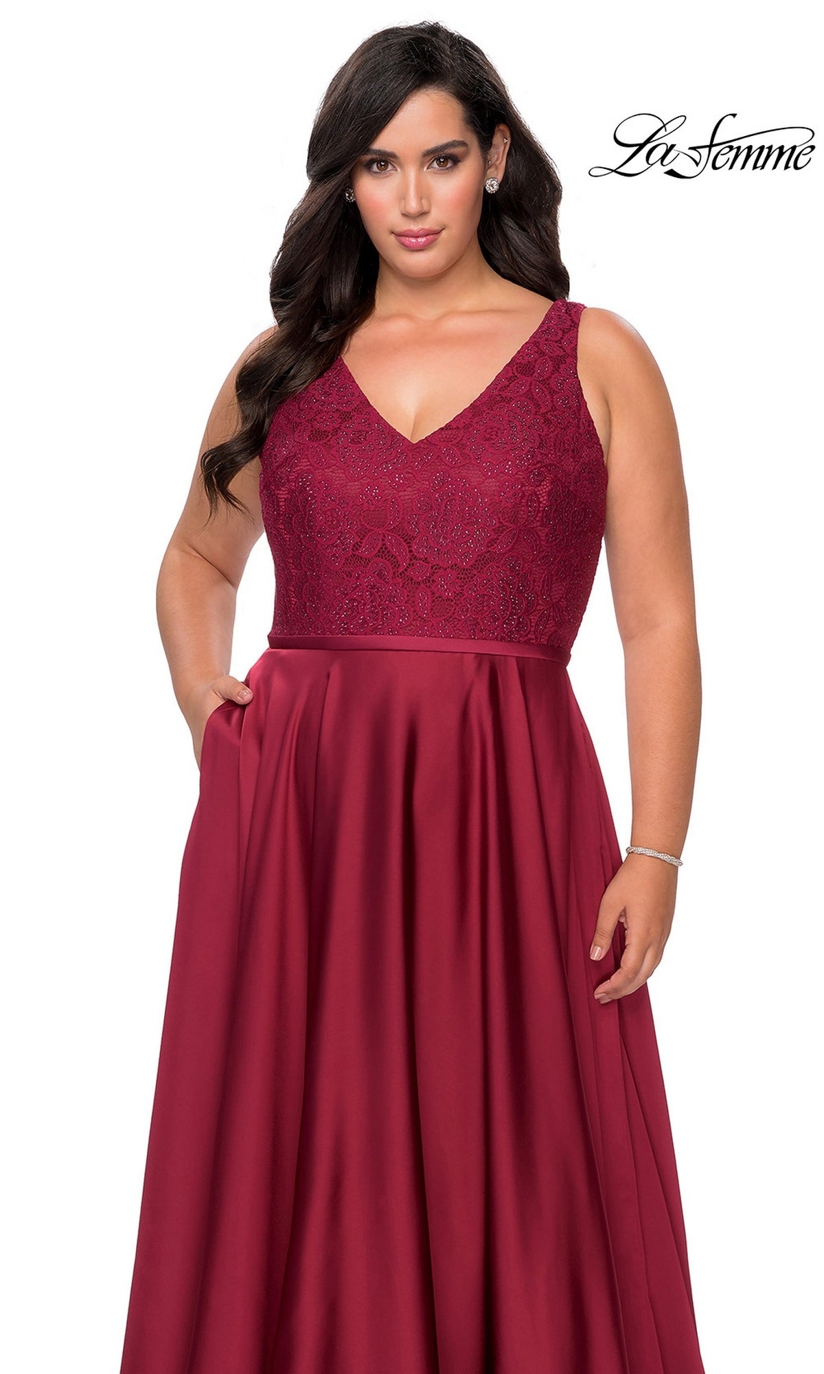 Long Plus-Size Prom Dress: La Femme 29004 is a sleeveless, floor-length burgundy satin A-line gown with a V-neckline, a rhinestone-embellished lace bodice, and a pleated skirt with pockets.