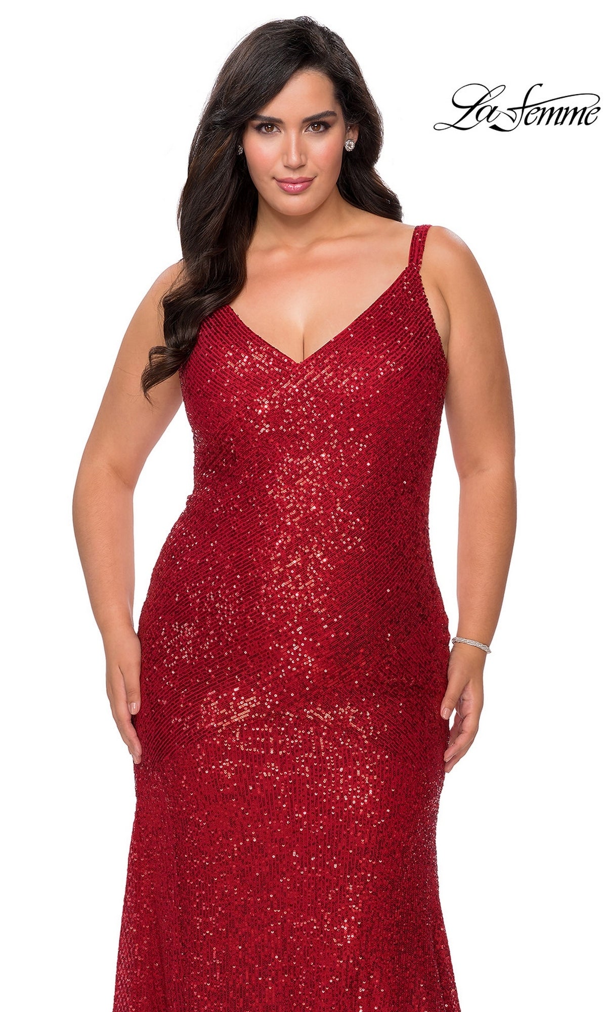 A woman wearing a floor-length, red sequined V-neck La Femme 29006 prom dress with spaghetti straps.