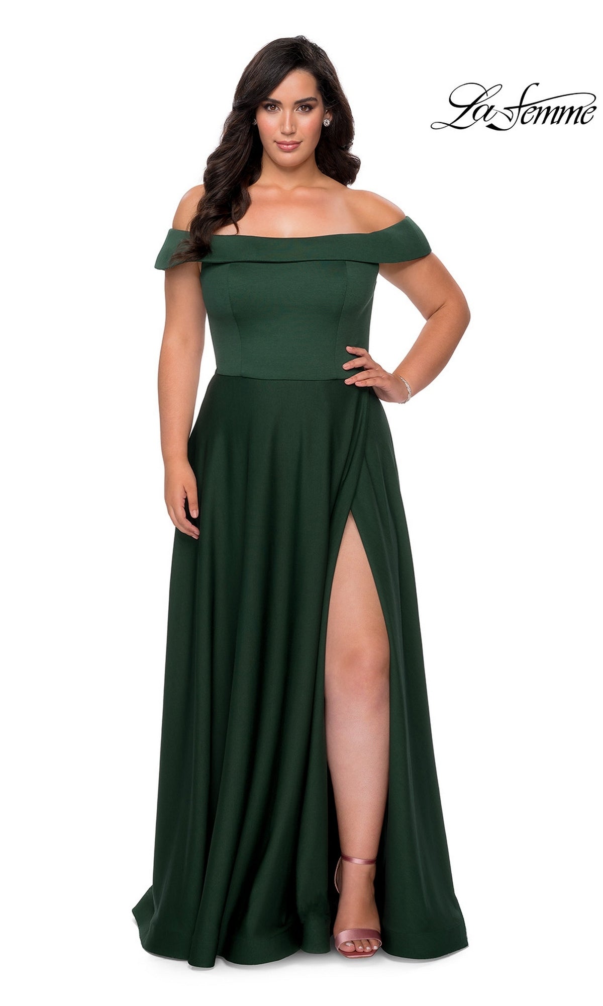 Woman in an emerald Long Plus-Size Prom Dress: La Femme 29007 with off-the-shoulder style and thigh-high slit, standing against a white background. “La Femme” logo in upper right.