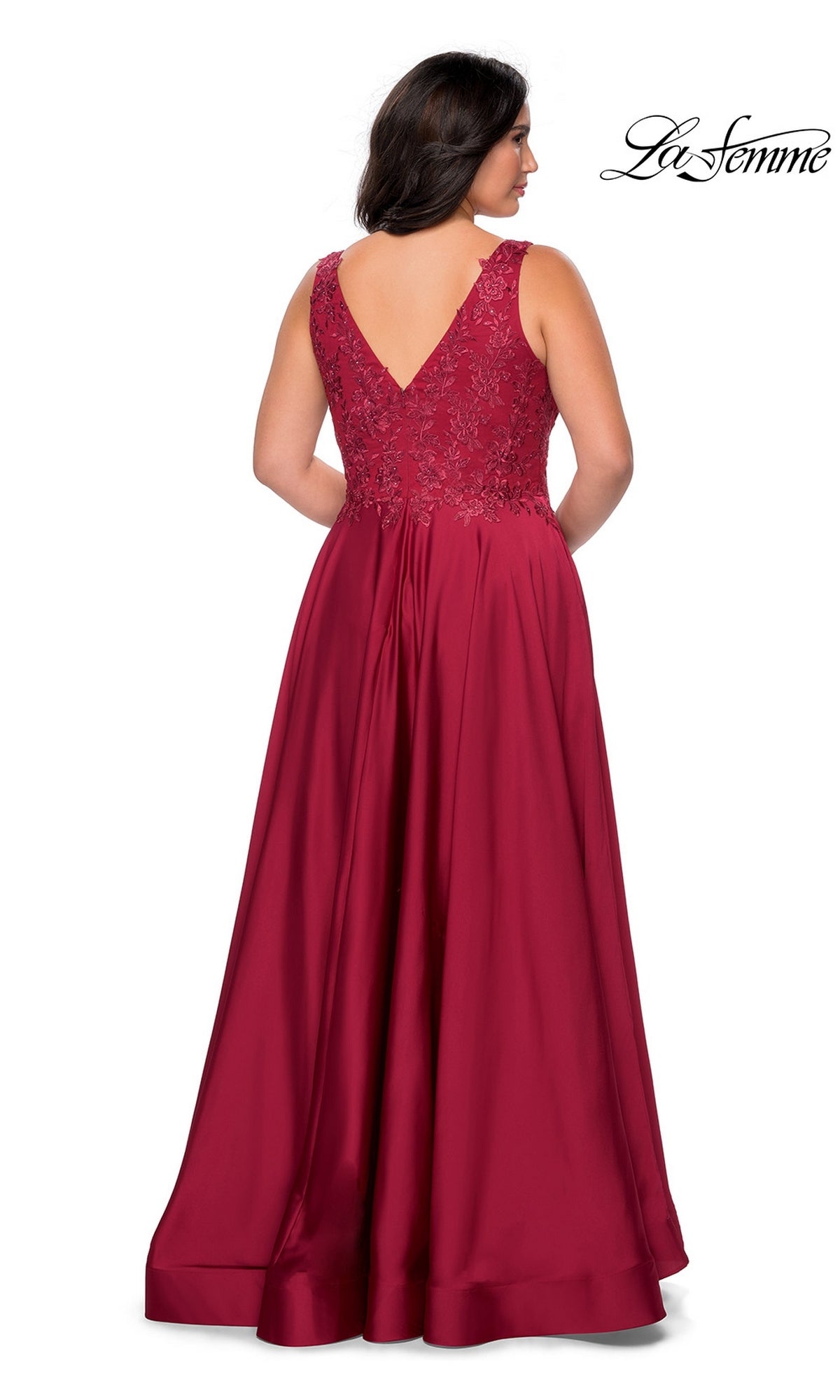 A woman seen from the back wearing a Long Plus-Size Prom Dress: La Femme 29039, a floor-length red dress with a V-neck and a rhinestone lace bodice.