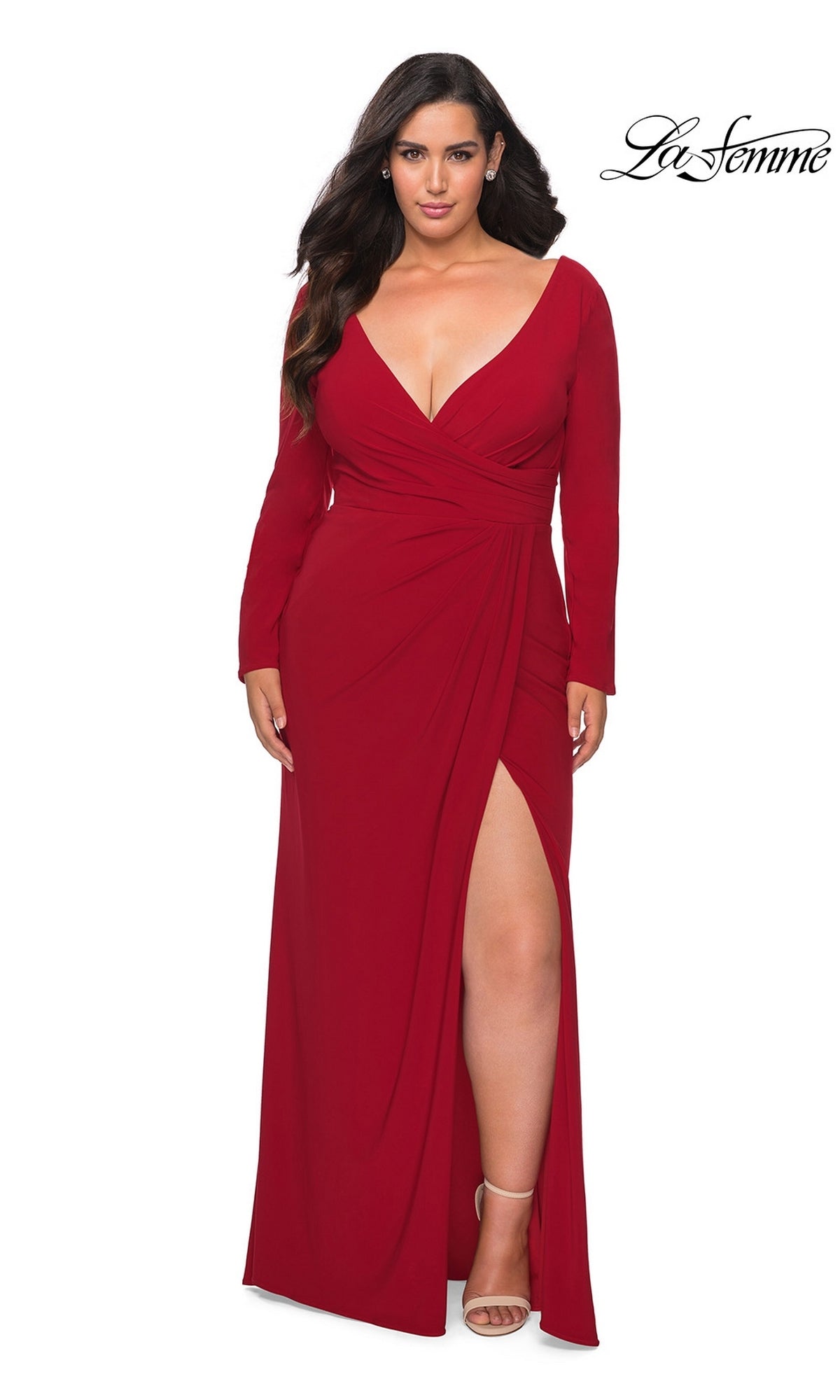 A woman wears a red La Femme 29044 long plus-size prom dress featuring a V-neck, faux wrap bodice, long sleeves, and a high side slit.