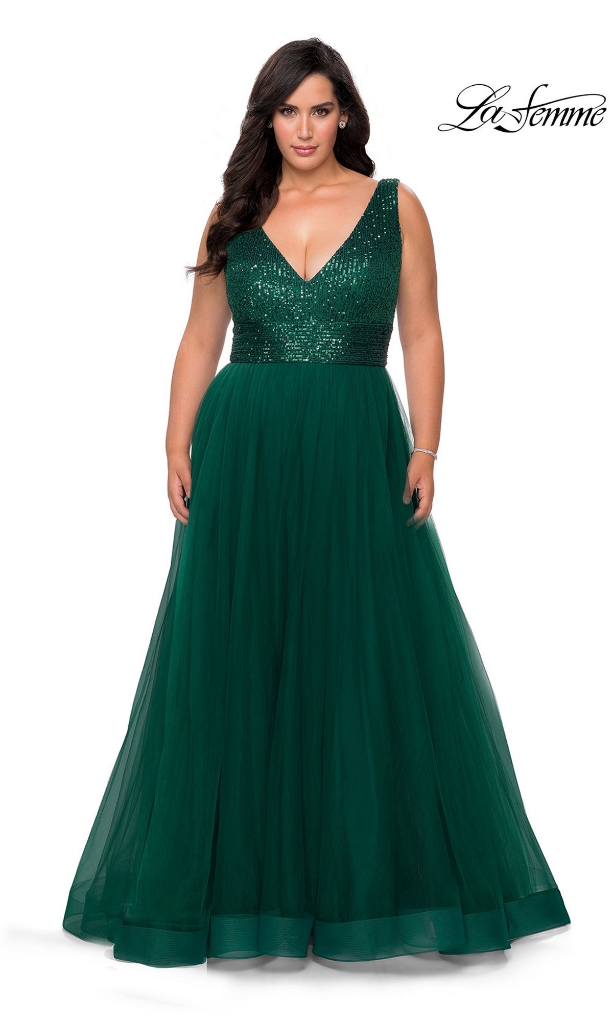 Woman in Long Plus-Size Prom Dress: La Femme 29045, emerald with sequin bodice and tulle A-line skirt, stands against a white background. “La Femme” logo top right.
