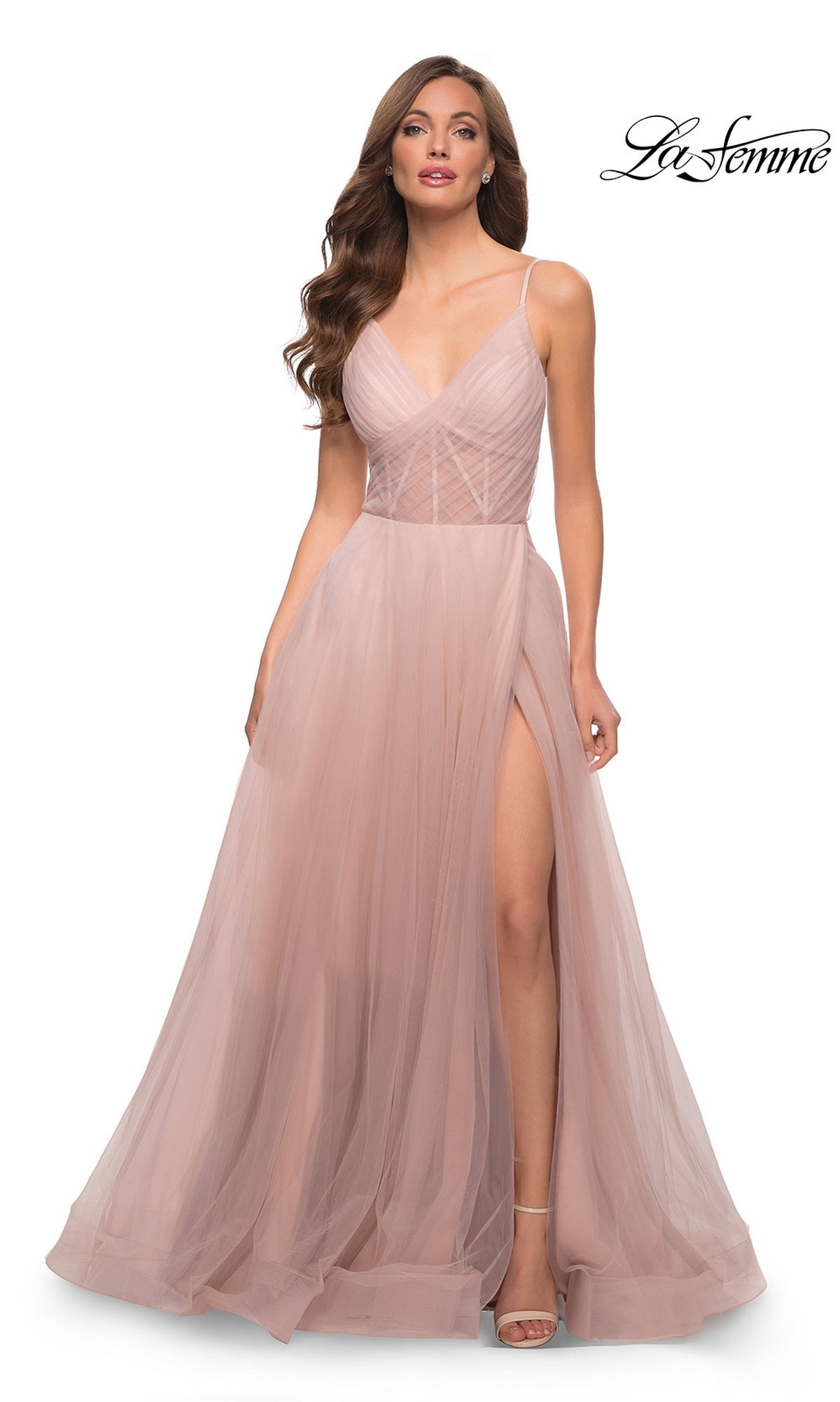 A woman wears the La Femme Sheer-Waist Long A-Line Prom Dress 29076 in dusty mauve, featuring spaghetti straps, a fitted bodice, a high leg slit, and a floor-length skirt;
