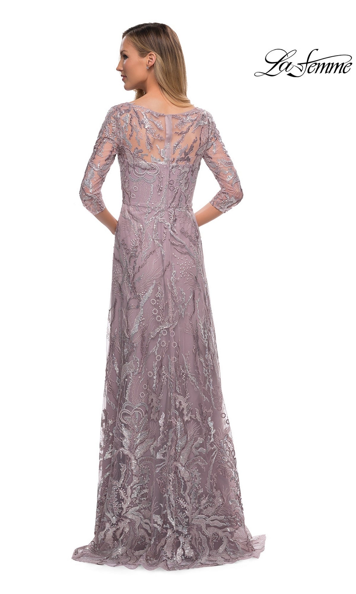 Woman stands facing away in the Long Formal Dress: La Femme 29233, a floor-length lavender gown with lace embroidery, beading, sheer back, and three-quarter sleeves.
