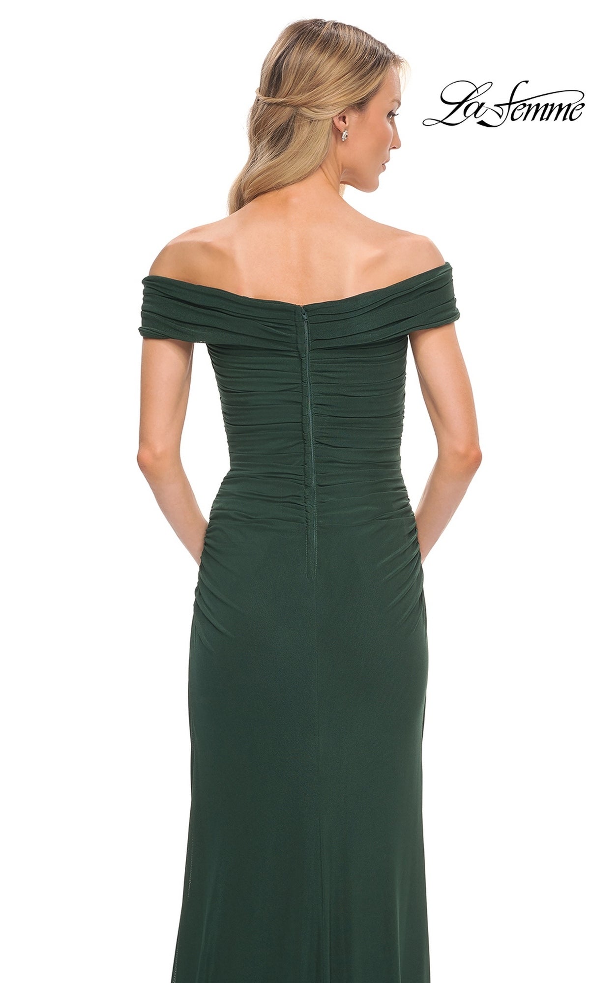 Woman in the Long Formal Dress: La Femme 29541, dark green, off-shoulder, ruched bodice, shown from the back with wavy blonde hair. “La Femme” logo top right.