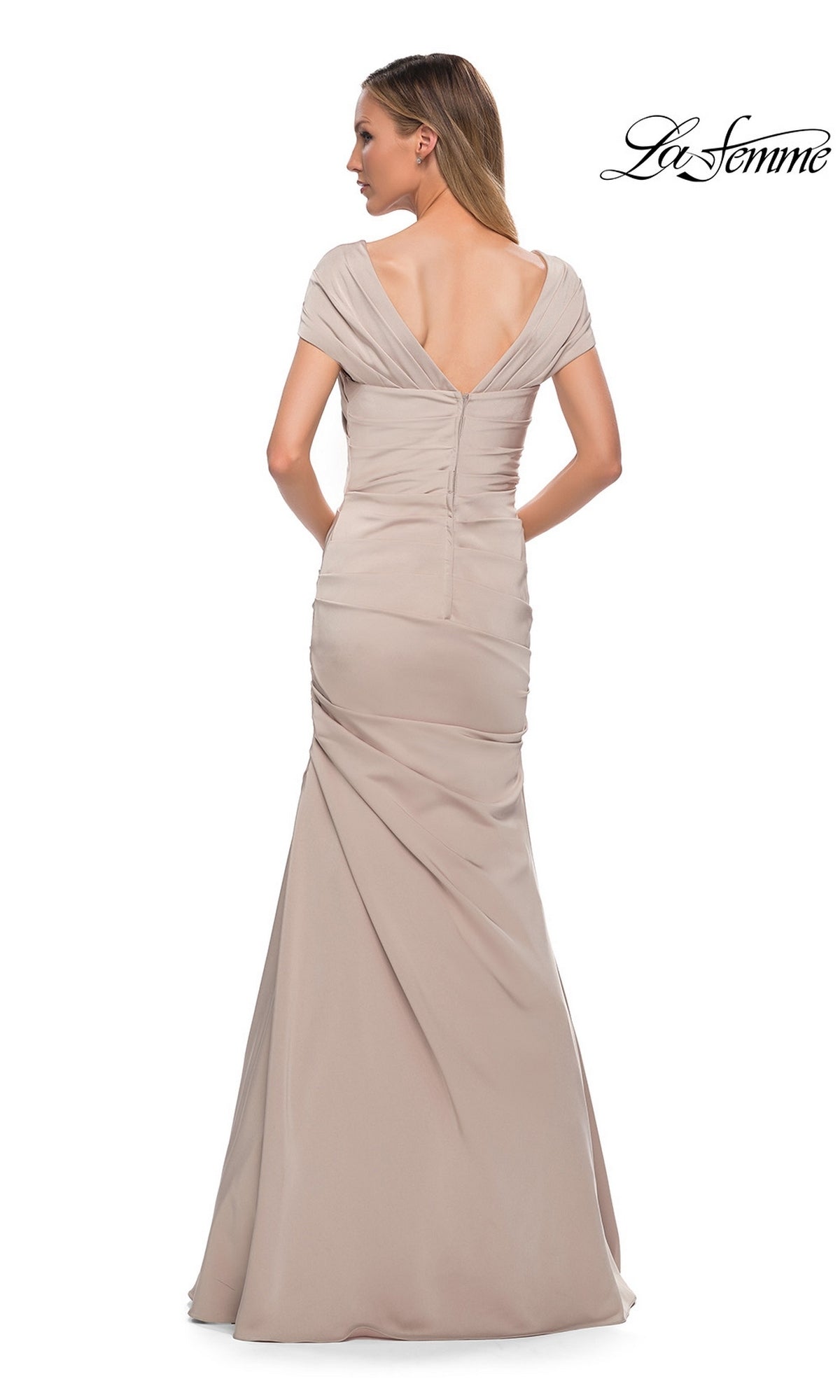 Back view of the Long Formal Dress: La Femme 29805, a floor-length, light tan trumpet silhouette formal dress with an off-the-shoulder neckline and draped skirt.