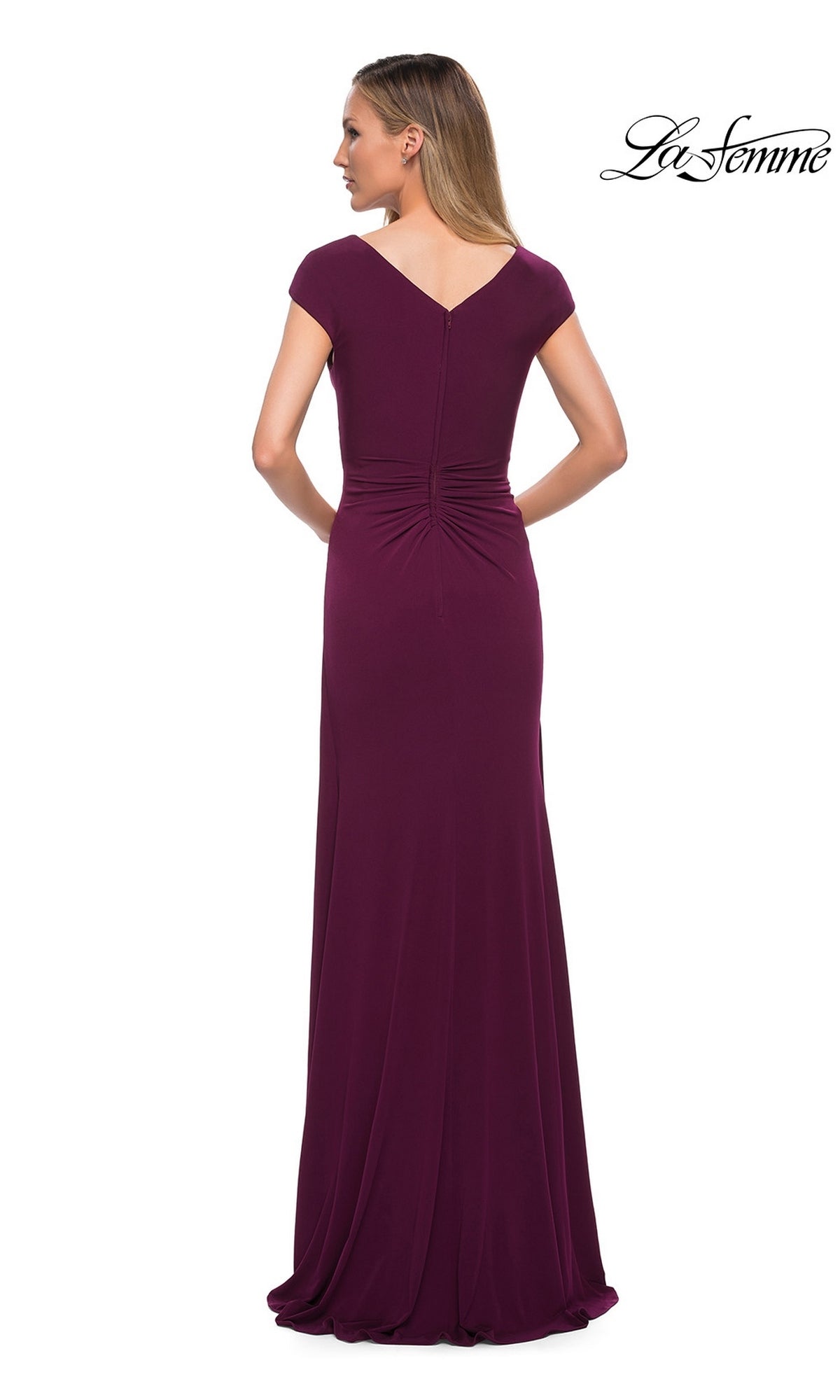 Back view of a woman wearing a floor-length, deep purple La Femme 29814 gown with cap sleeves, a gathered waist, and a cascading ruffle.