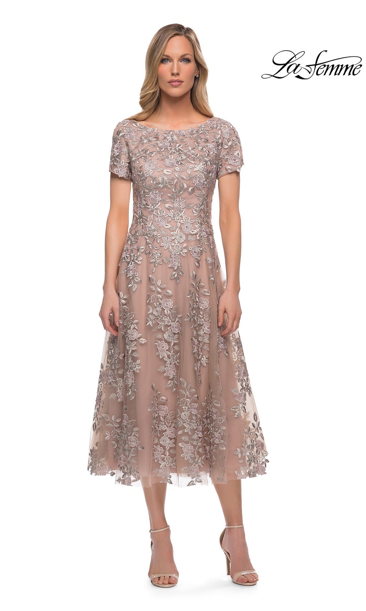 Woman in the Midi Mother of Bride Dress: La Femme 29830—mauve, knee-length, short sleeves, floral lace; “La Femme” logo in top right corner on white background.