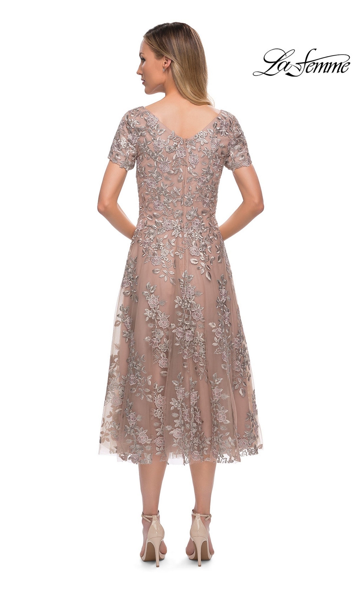 Woman wears the Midi Mother of Bride Dress: La Femme 29830, blush pink with silver lace, heels visible. Perfect for mothers of the bride. “La Femme” logo in corner.