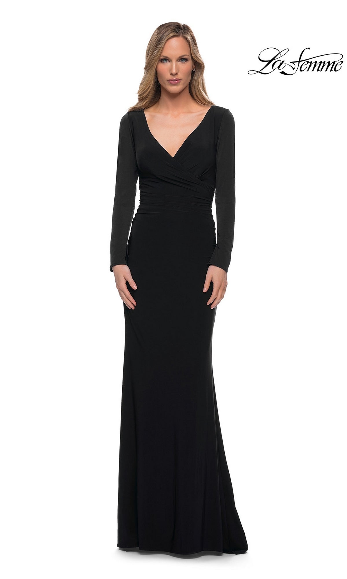A woman wears a black La Femme 29924 floor-length jersey dress with a V-neckline and a ruched bodice.