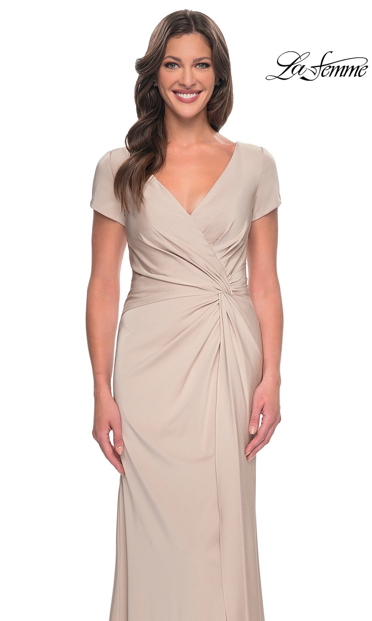 A woman wearing a tan, floor-length Long Formal Dress: La Femme 29926 featuring a twist-knot design, V-neck, cap sleeves, and a gathered waist.