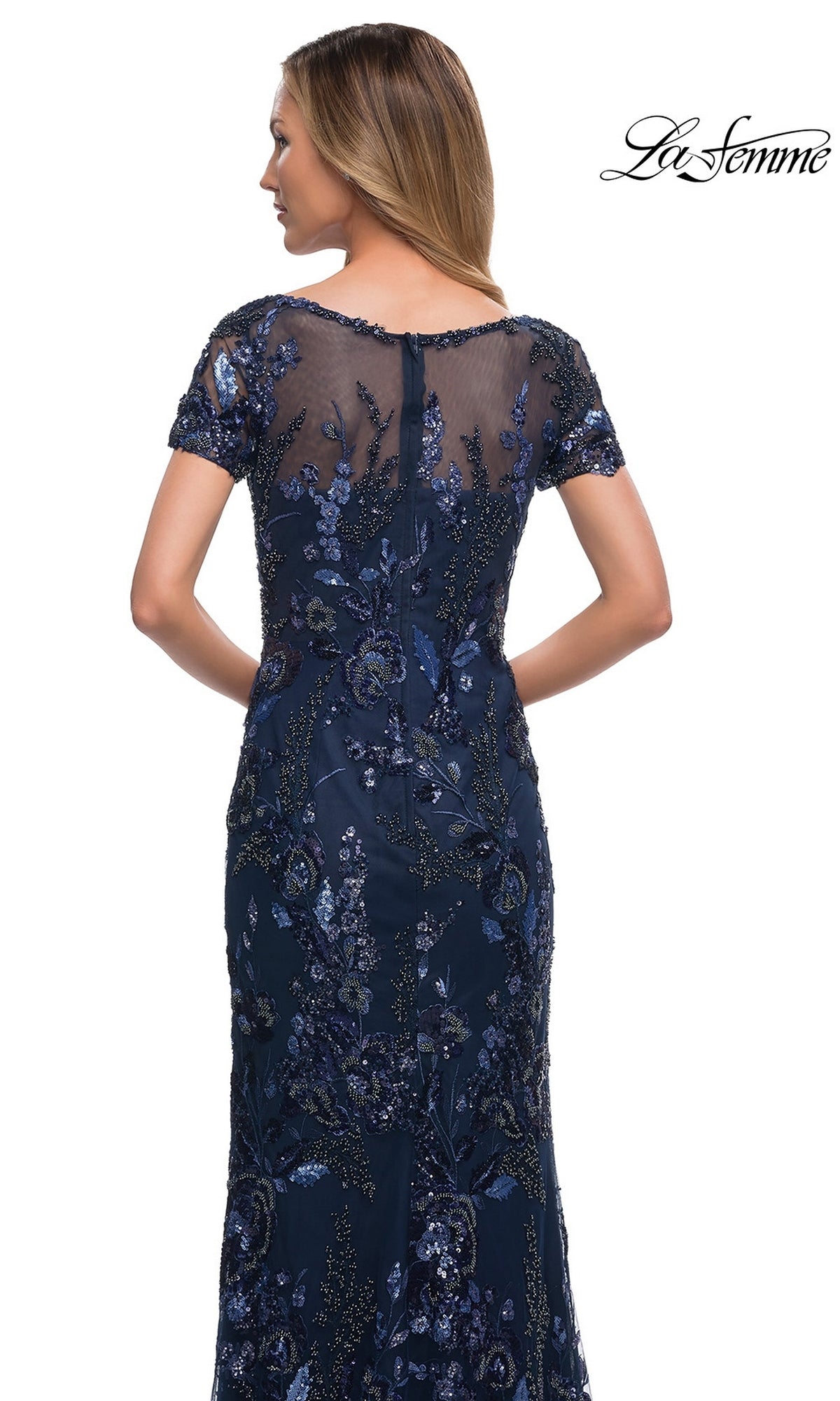Woman wearing Long Formal Dress: La Femme 29961—navy blue, short sleeves, floral sequin embroidery—shown from the back. “La Femme” logo top right.