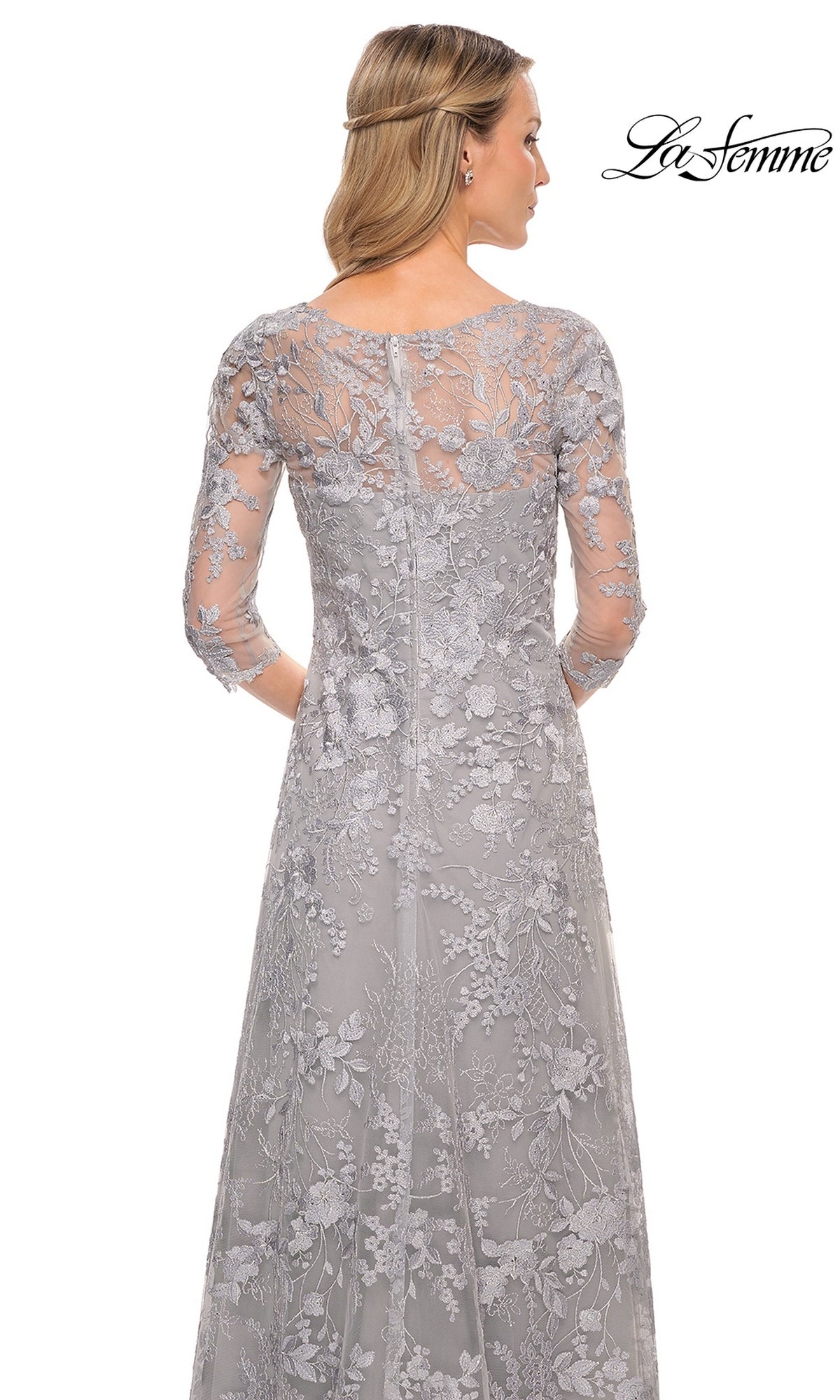 Back view of a woman in a Long Formal Dress: La Femme 29989, a floor-length gray silver gown with three-quarter sleeves and an embroidered floral lace overlay.