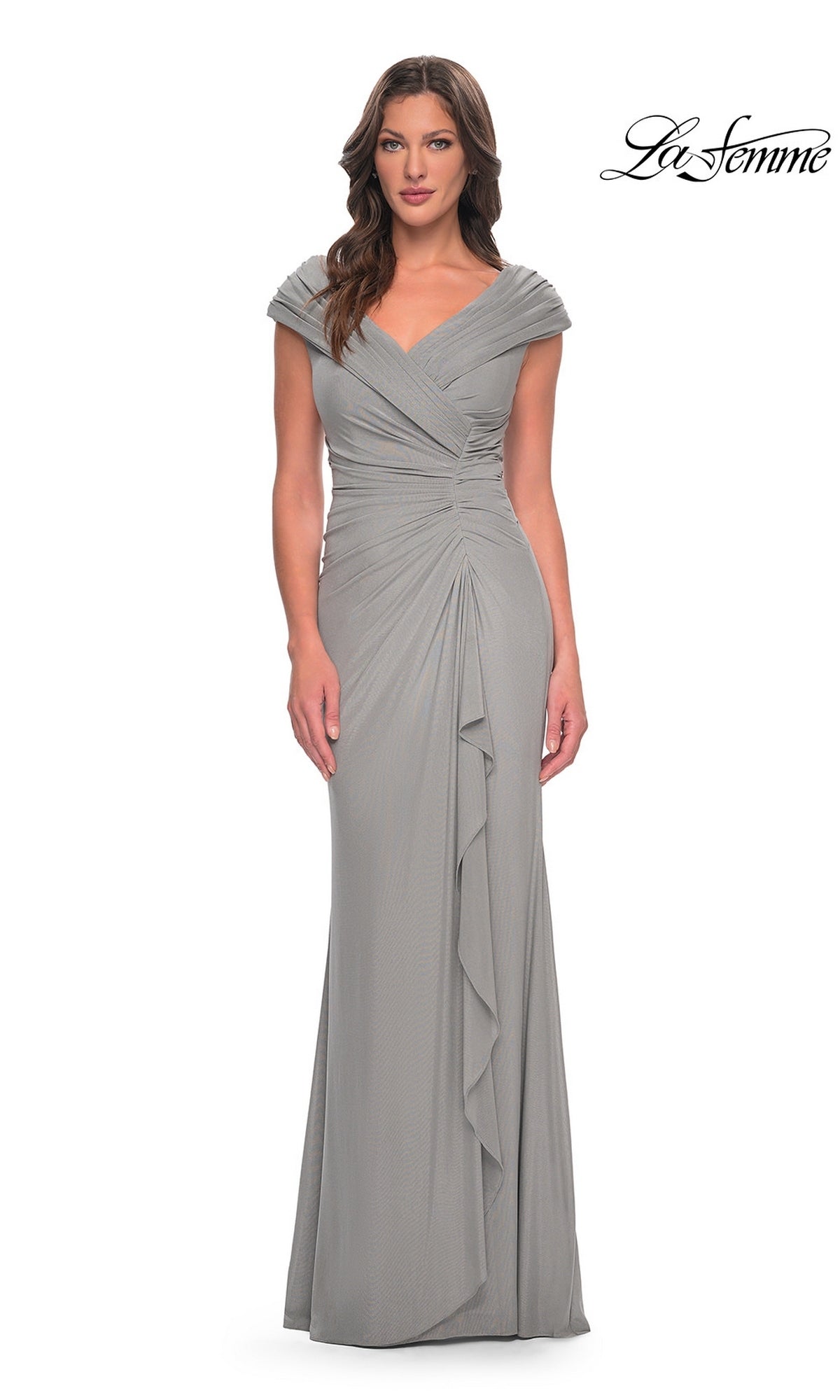 A woman wears a silver Long Formal Dress: La Femme 29996, featuring a V-neck, cap sleeves, and a draped bodice with a side ruffle.