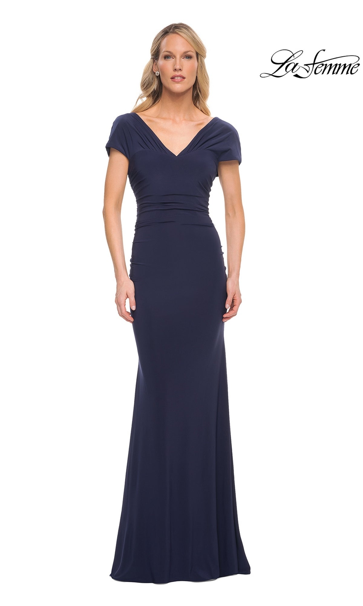 A woman wears the Long Formal Dress: La Femme 29998, a modest, floor-length navy gown featuring a V-neckline, cap sleeves, and a fitted sheath skirt.