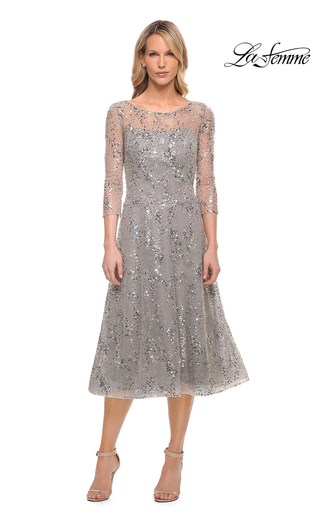 A silver Midi Mother of Bride Dress: La Femme 30002 featuring a fit-and-flare silhouette, three-quarter sleeves, a sheer neckline, and sequin and beaded embellishments, worn with beige heeled sandals.