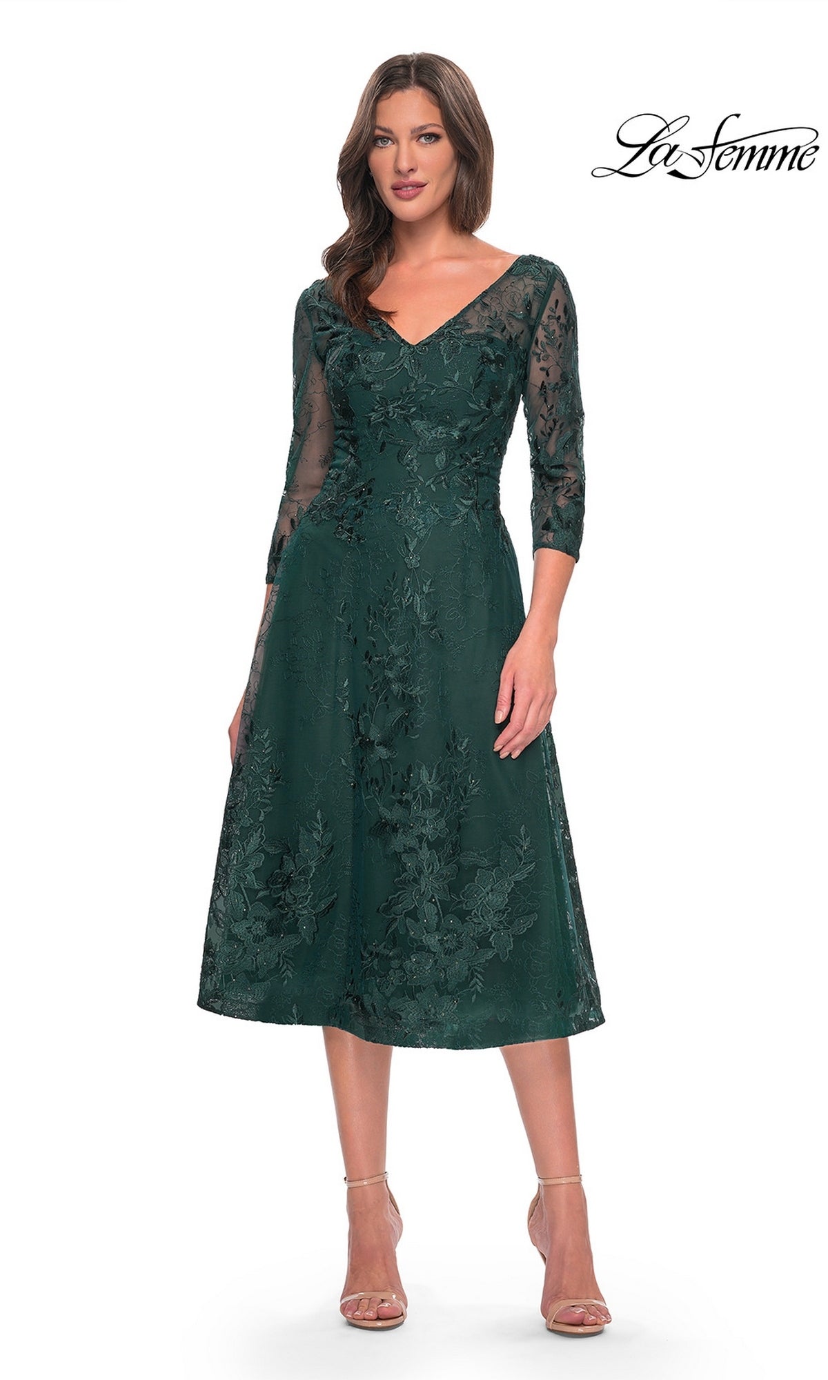 A woman wearing a dark green, midi-length Midi Wedding Guest Dress: La Femme 30016 with three-quarter sleeves and floral lace embroidery.