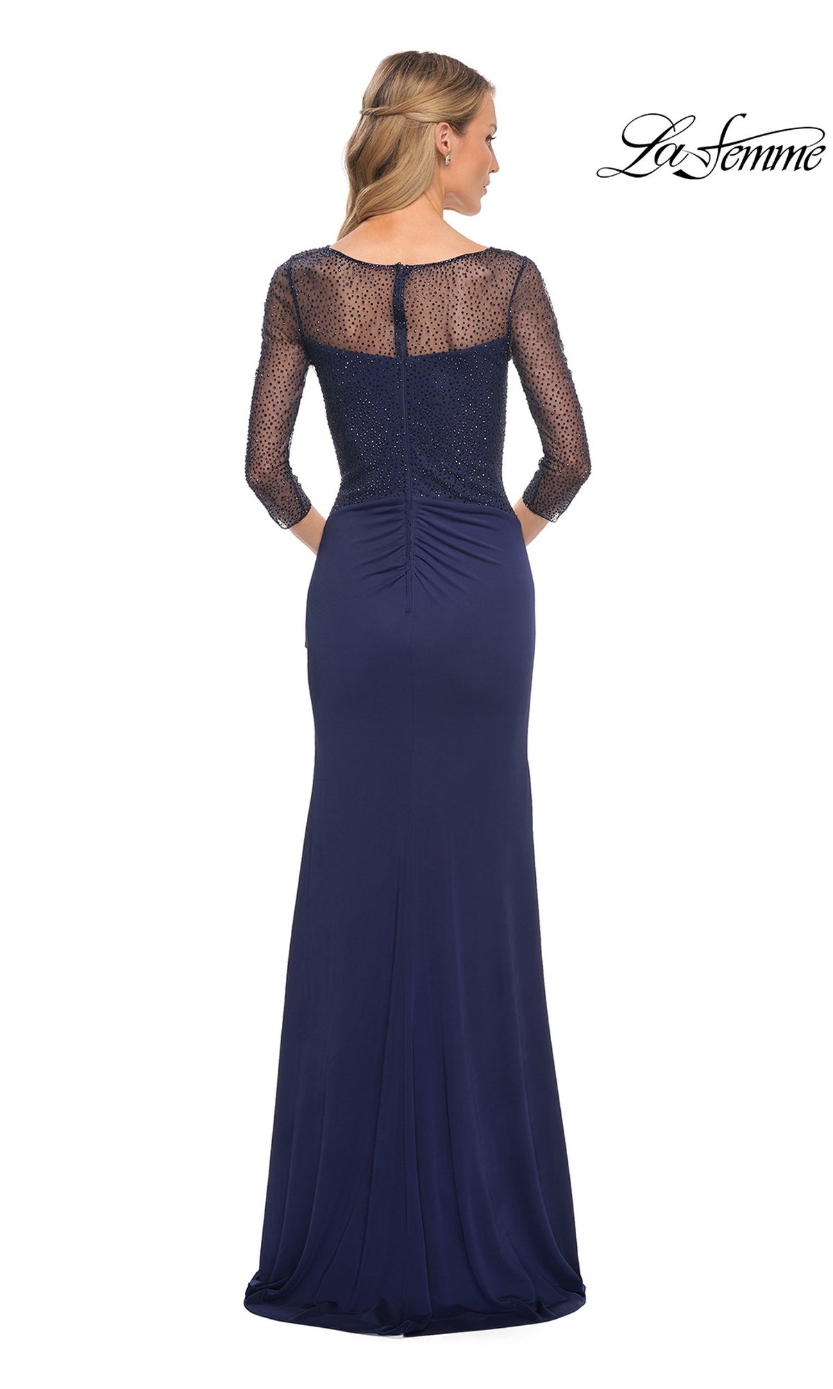 Woman in a floor-length navy Long Formal Dress: La Femme 30028 with beaded applique sleeves and sheer back, facing away; La Femme logo in top right.