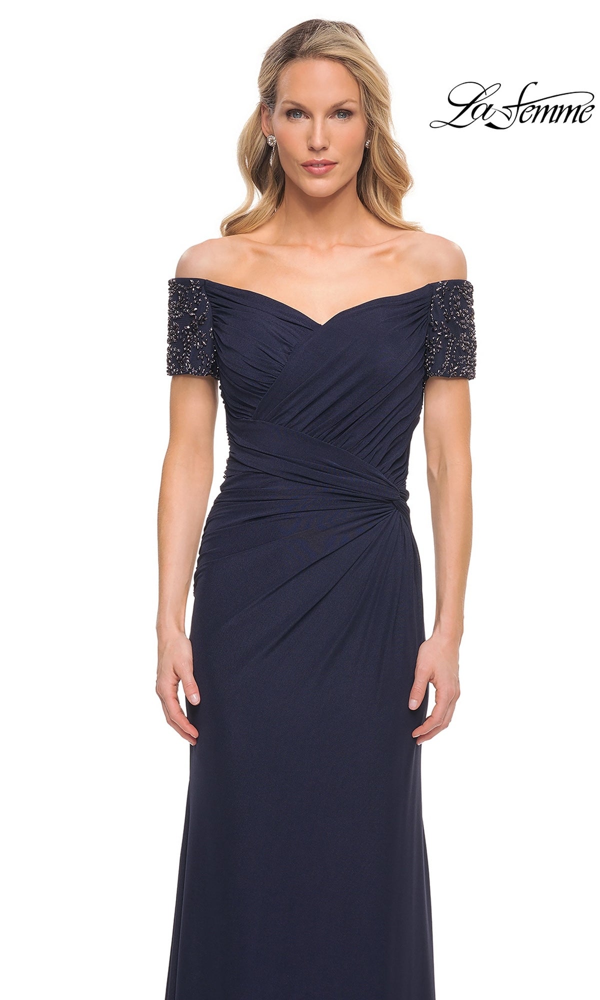 Woman wearing the Long Formal Dress: La Femme 30057, a navy blue off-the-shoulder gown with beaded short sleeves, against a plain white background.