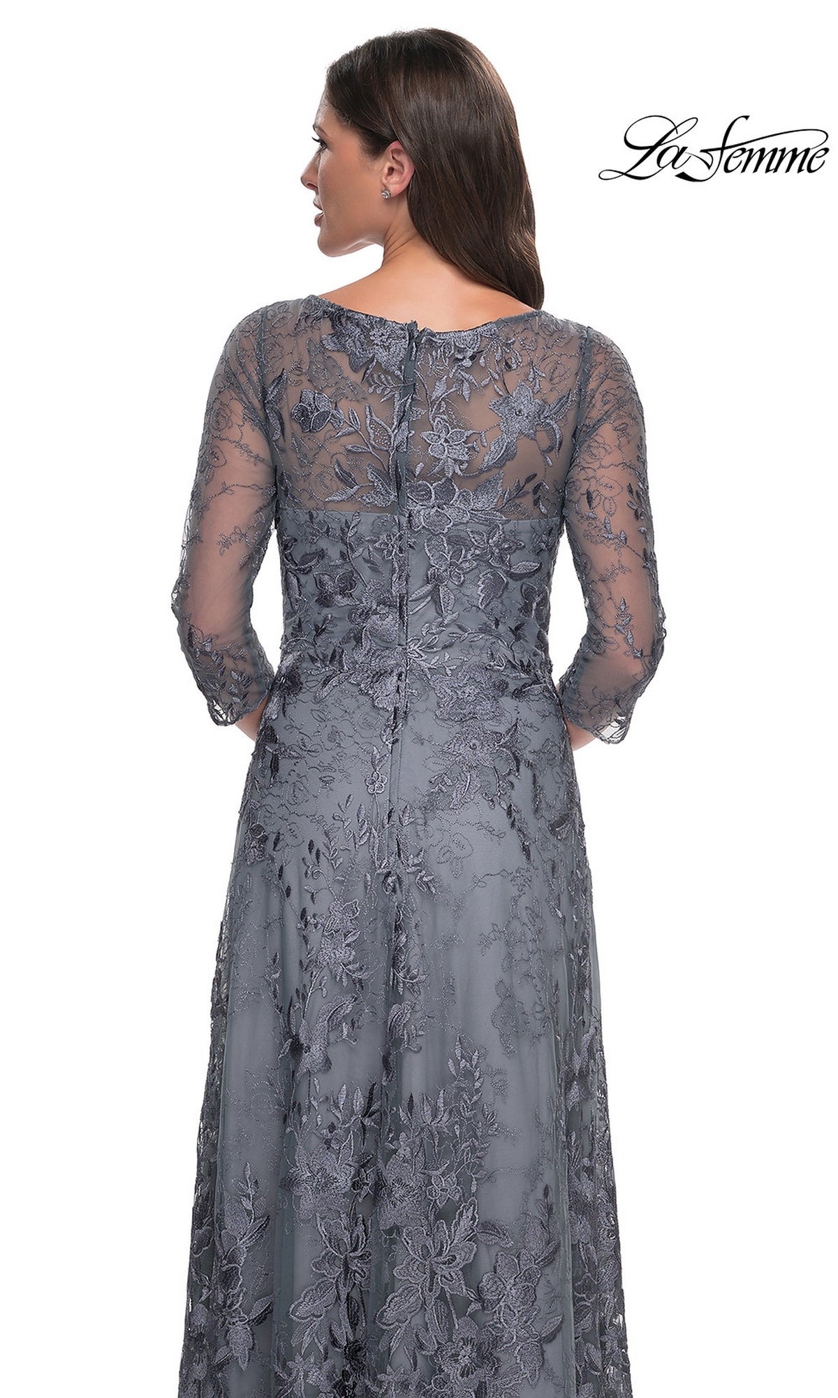Back view of a woman in a La Femme 30060 floor-length slate grey lace formal dress with three-quarter sleeves and floral embroidery.