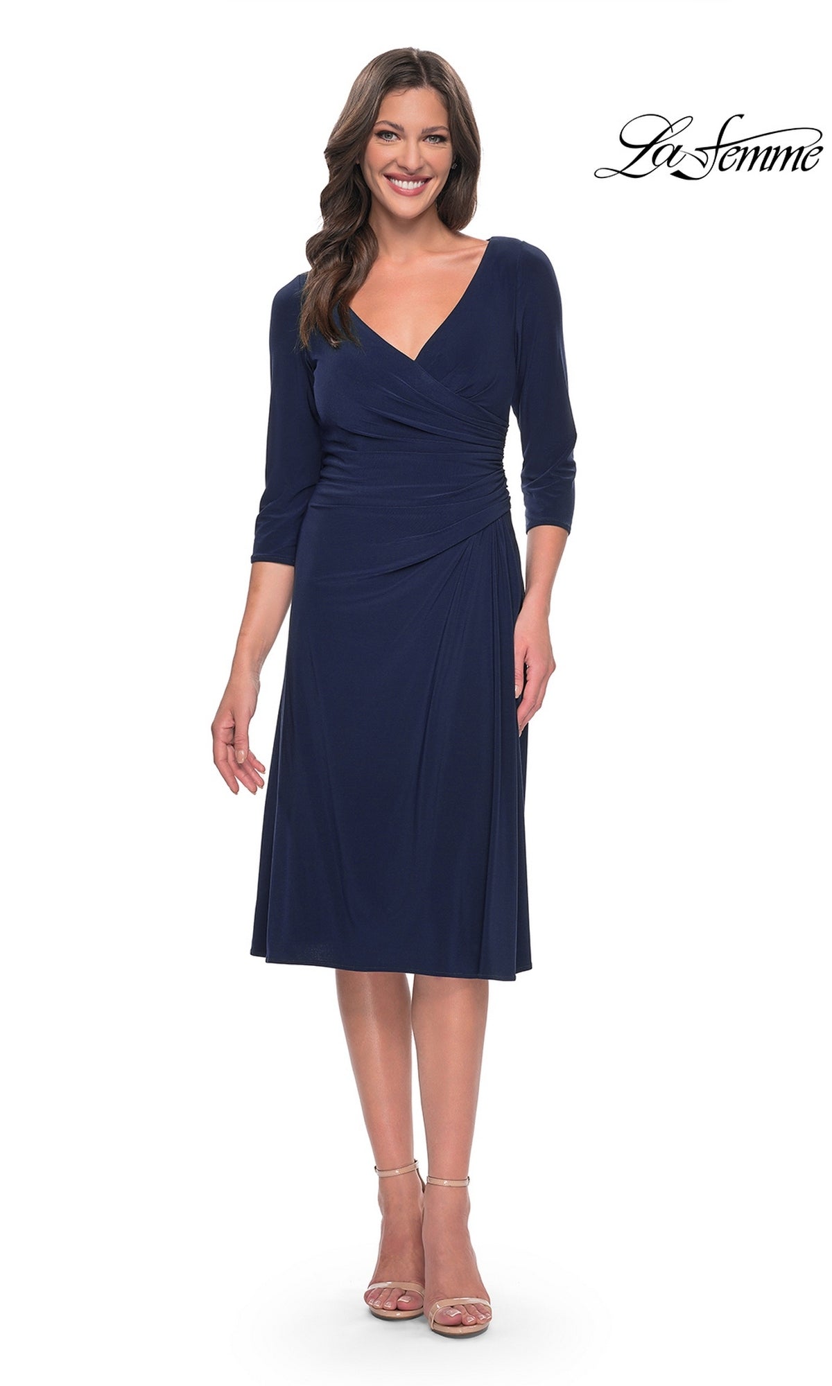 A woman wearing the navy Midi Wedding Guest Dress: La Femme 30069, a fit-and-flare midi dress with a V-neckline and three-quarter length sleeves.