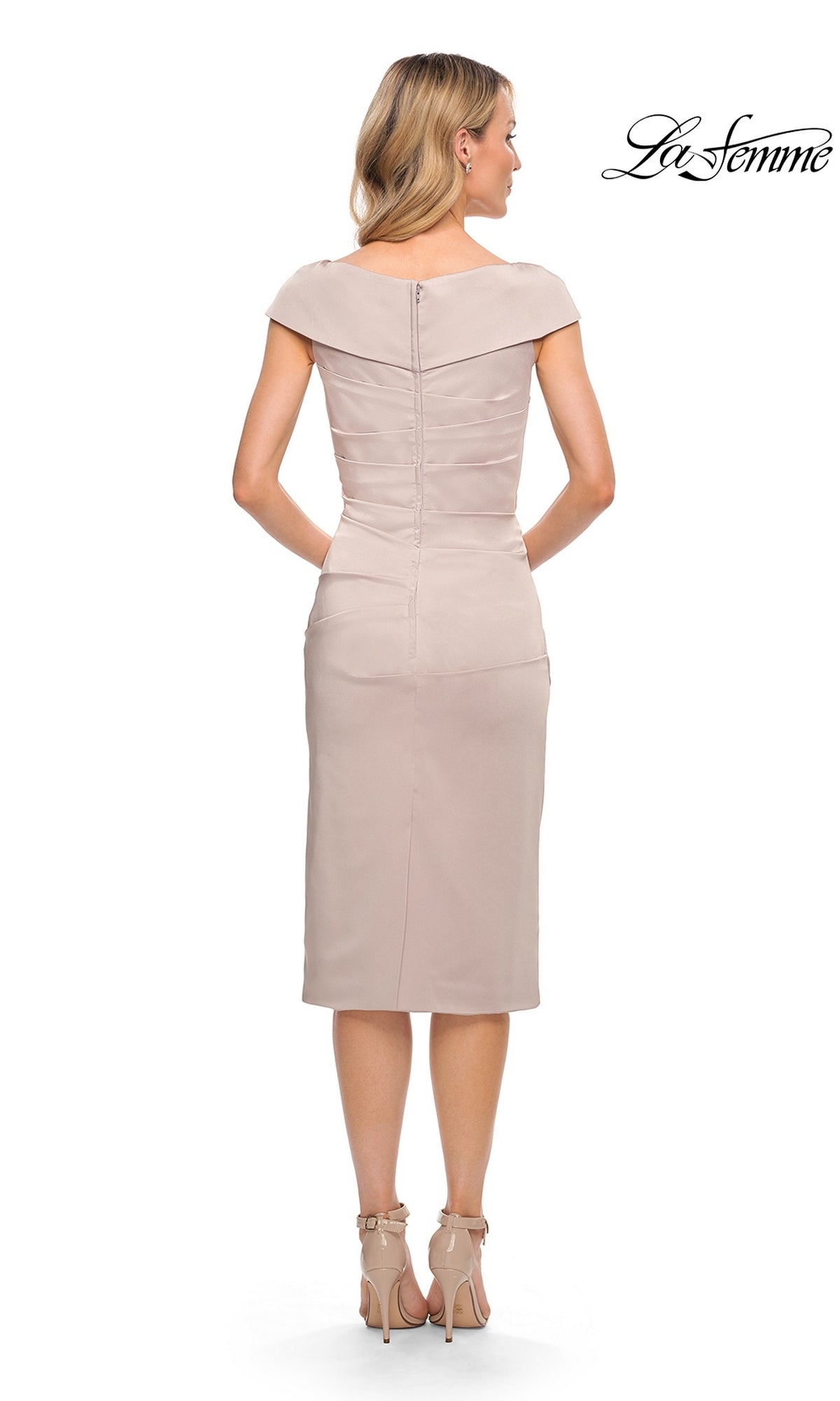 Back view of a woman wearing a La Femme 30110 midi wedding guest dress in beige with an off-the-shoulder fold-over neckline, ruched detailing, and matching ankle-strap heels.