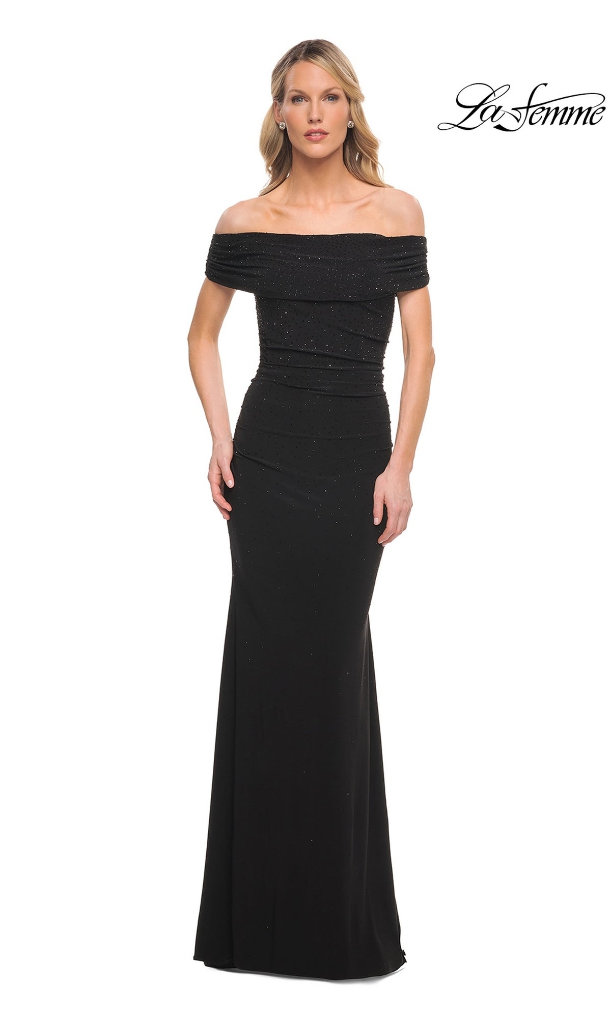 A woman wearing a black, off-shoulder floor-length La Femme 30117 evening gown with subtle sparkles.