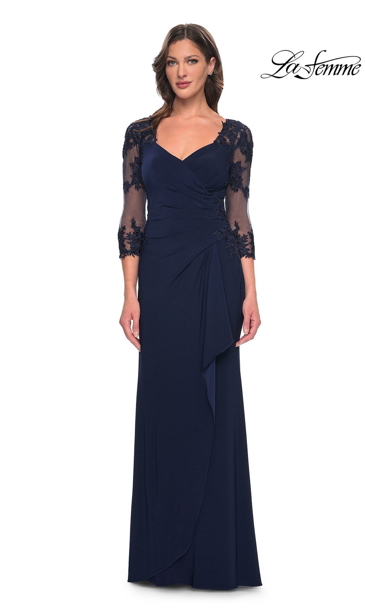 Woman in a navy Long Formal Dress: La Femme 30384 with sheer lace sleeves and floral embroidery, standing before a white background with “La Femme” logo.