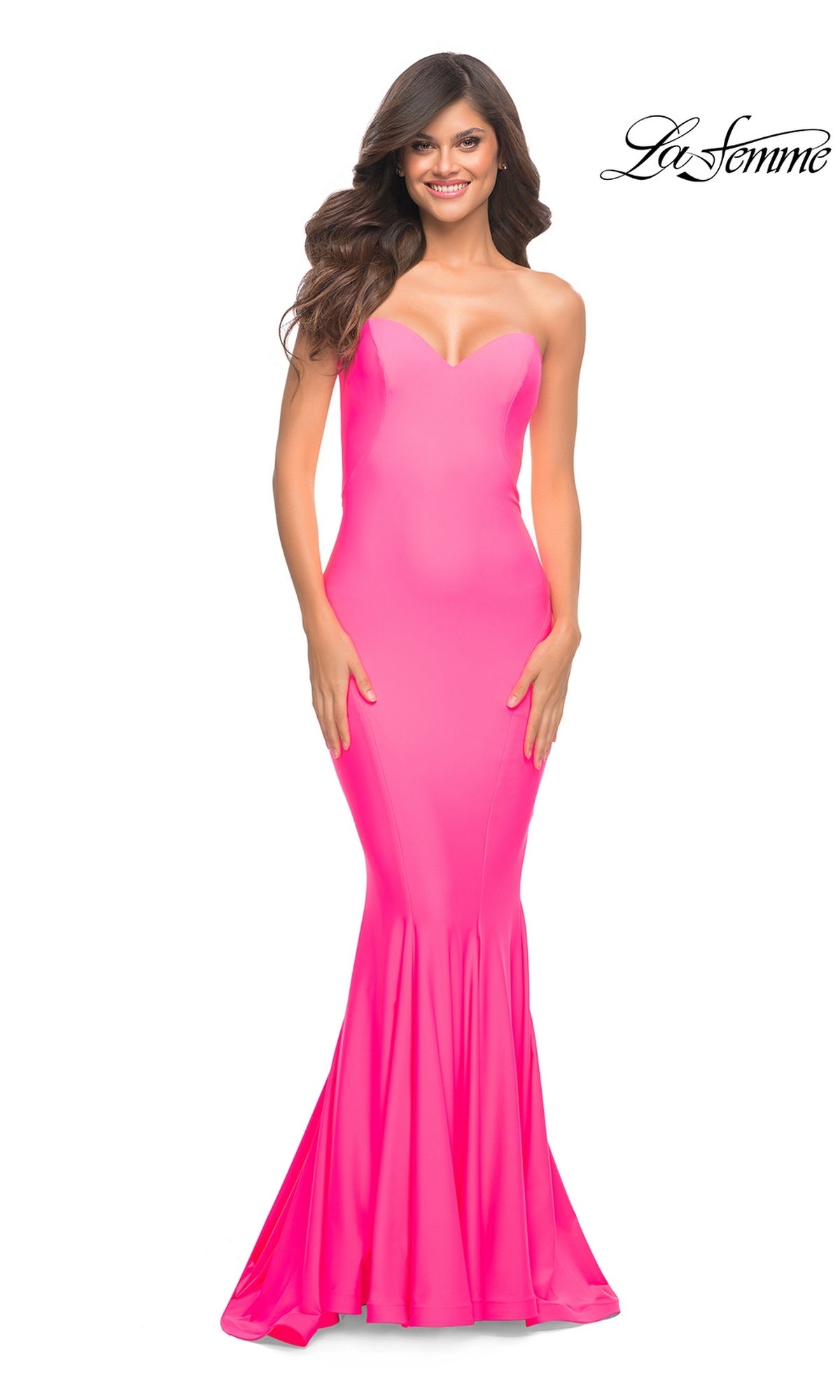 A woman wears a neon pink, floor-length, strapless mermaid Long Prom Dress: La Femme 30648.