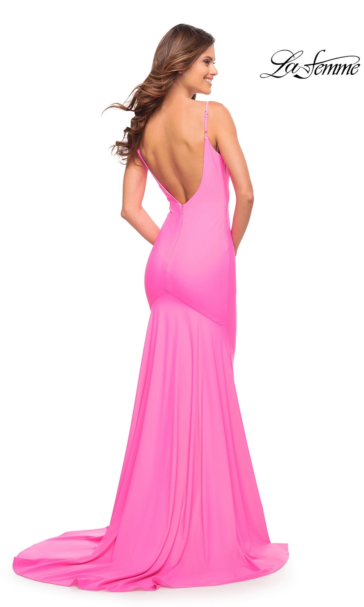 A woman wearing a La Femme 30682 floor-length, hot pink gown with a figure-hugging silhouette, a low, open back, and spaghetti straps.