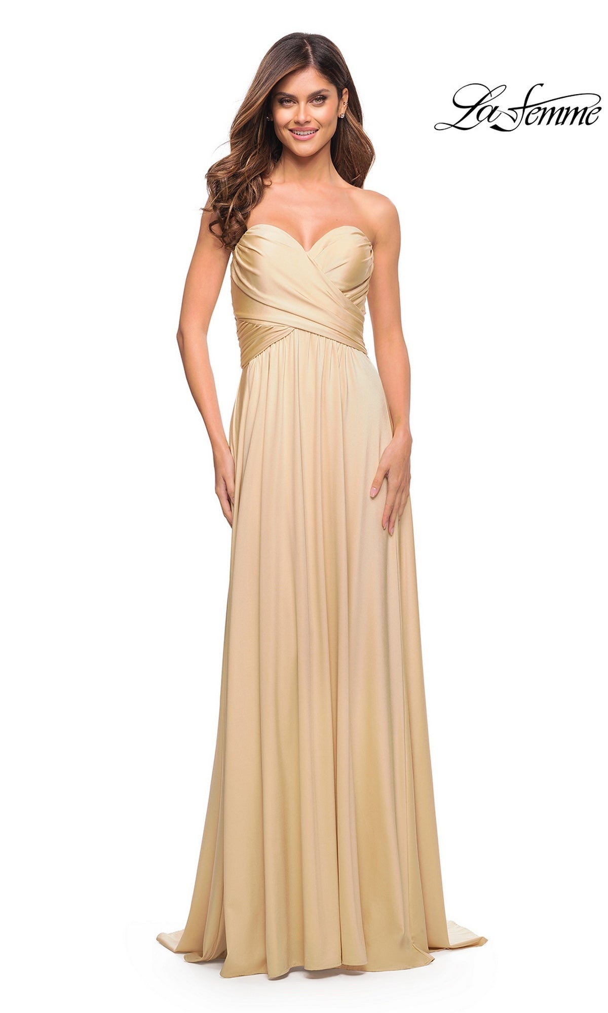 Woman wearing the Long Prom Dress: La Femme 30700, a strapless, floor-length light gold gown with a sweetheart neckline and gathered bodice, smiling against a white background.