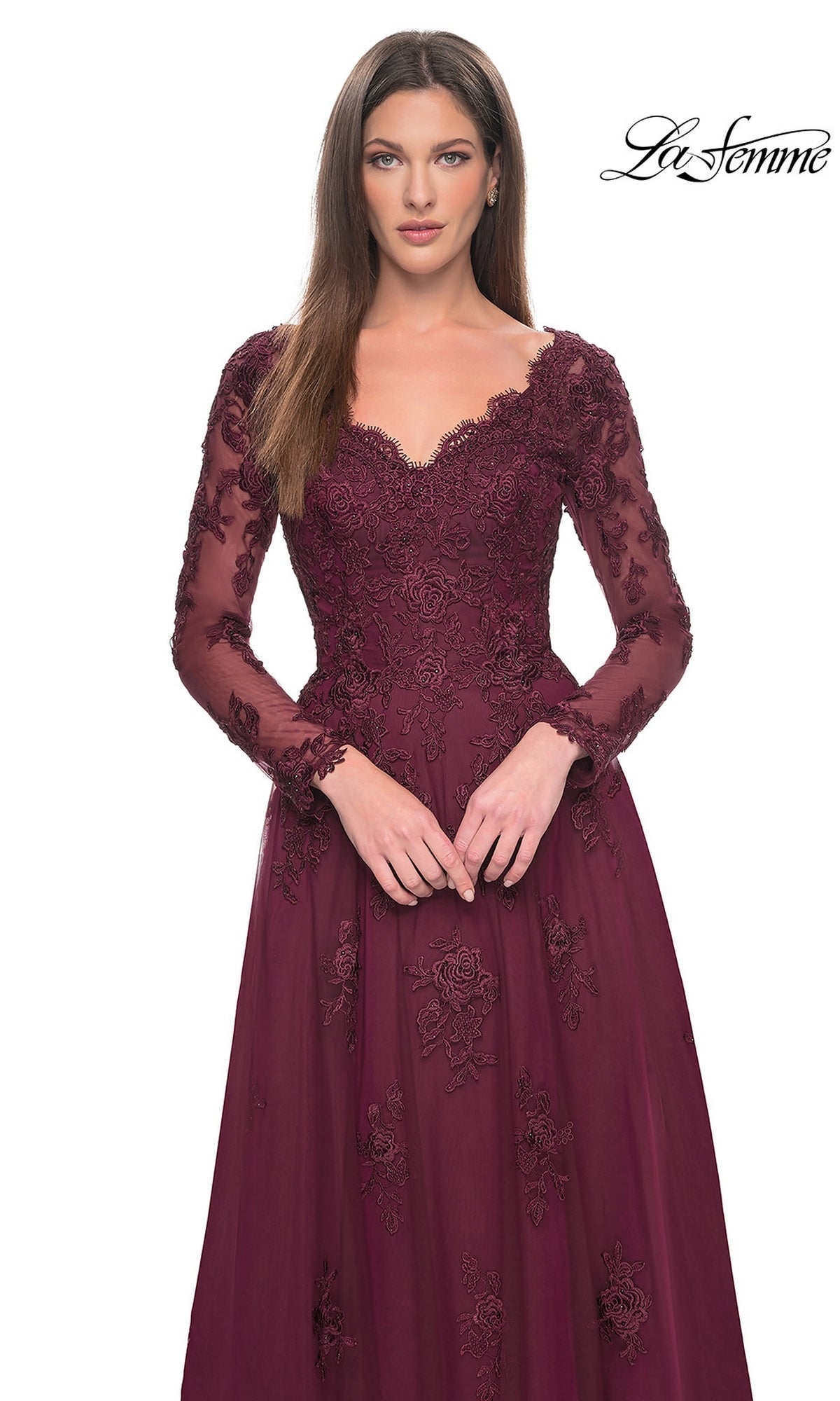 A woman wears the Long Formal Dress: La Femme 30795, a burgundy V-neck gown featuring beaded lace appliques and a tulle A-line skirt.