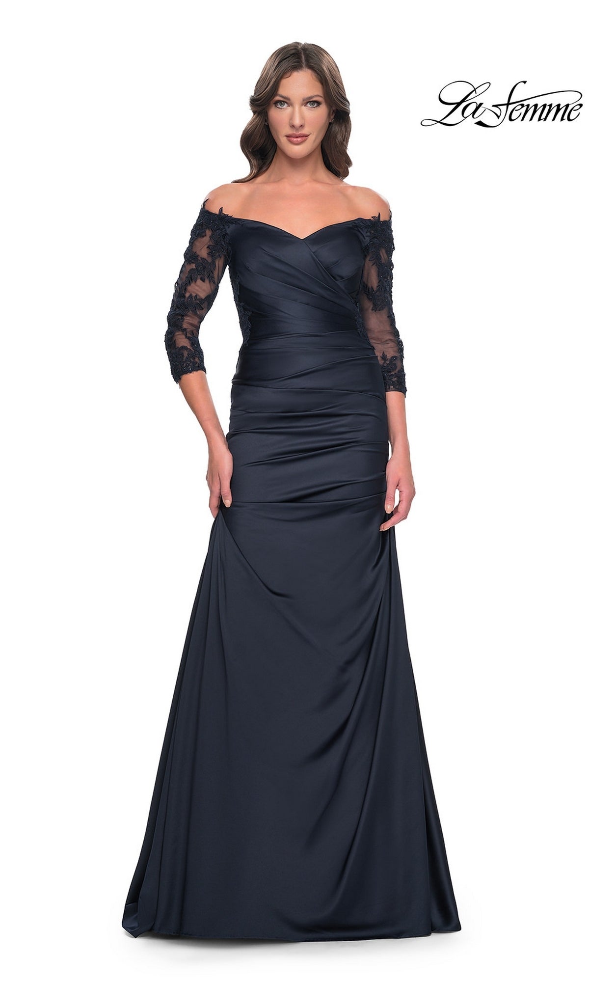 A woman wears a navy Long Formal Dress: La Femme 30853, an off-the-shoulder gown with three-quarter length lace sleeves and a ruched bodice.