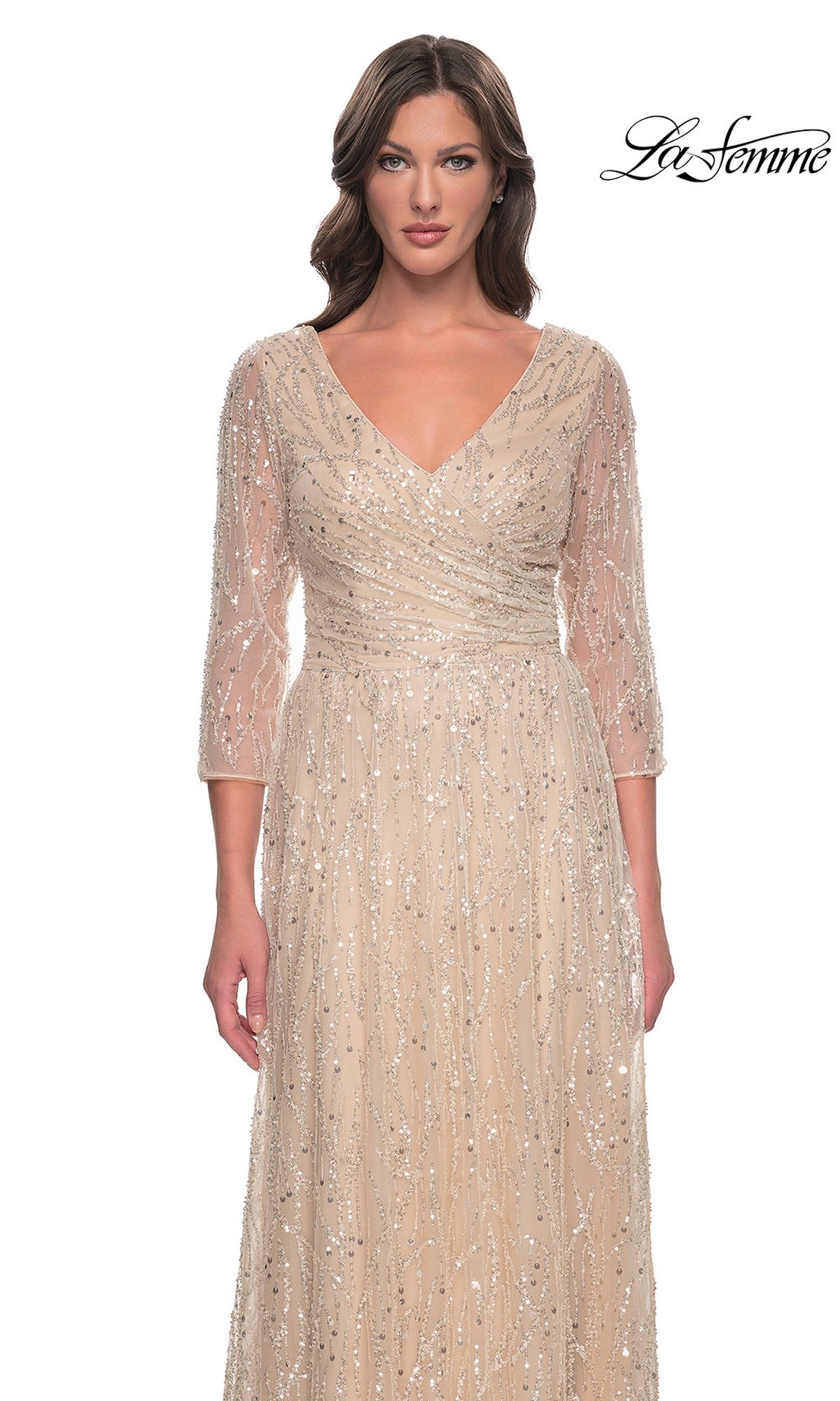 A woman wears a tan, v-neck Long Formal Dress: La Femme 30911, a champagne formal gown with three-quarter sleeves and all-over vertical sequin and bead embellishments.