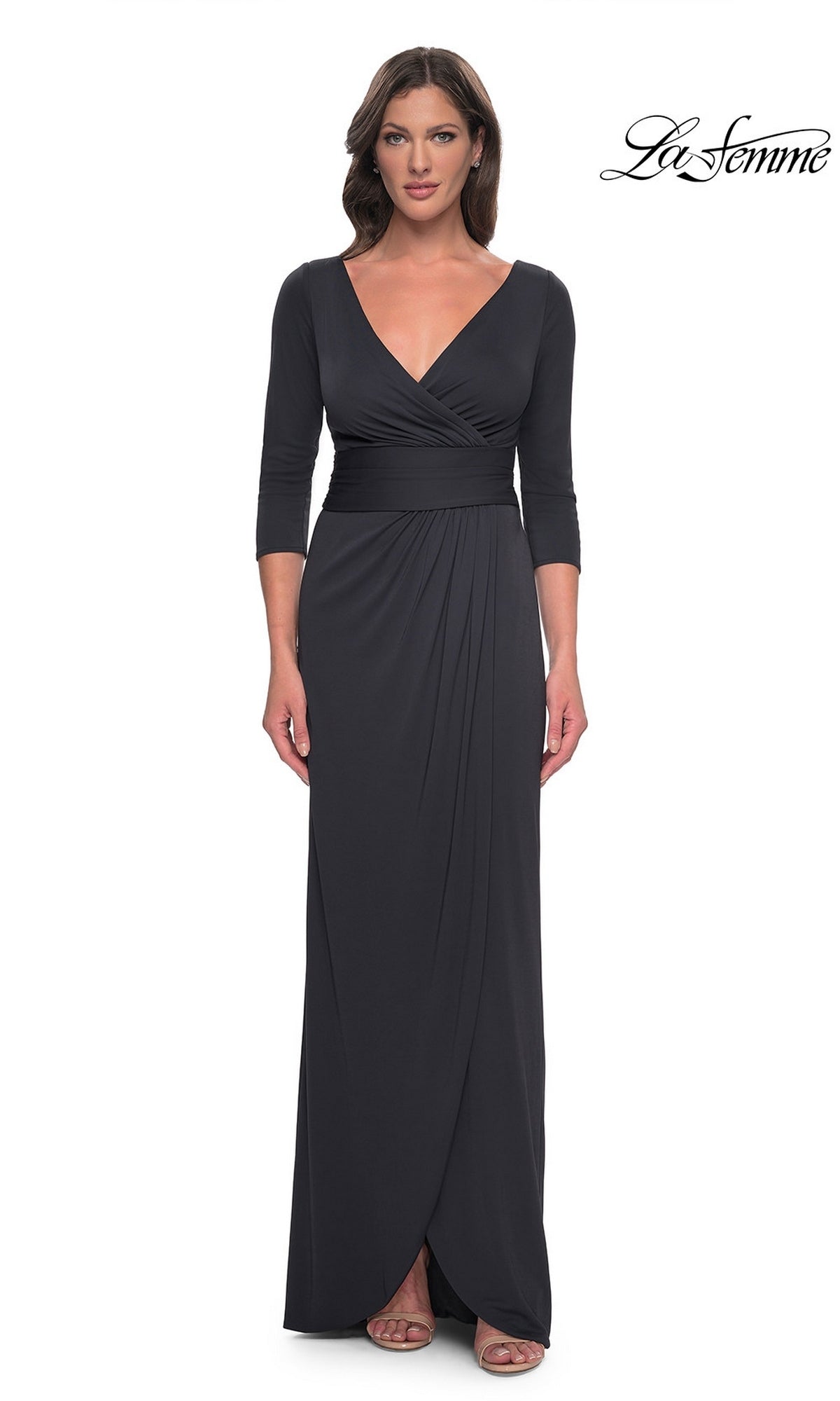 A woman wears a charcoal Long Formal Dress: La Femme 31014, a floor-length jersey V-neck dress with three-quarter length sleeves and a draped skirt.