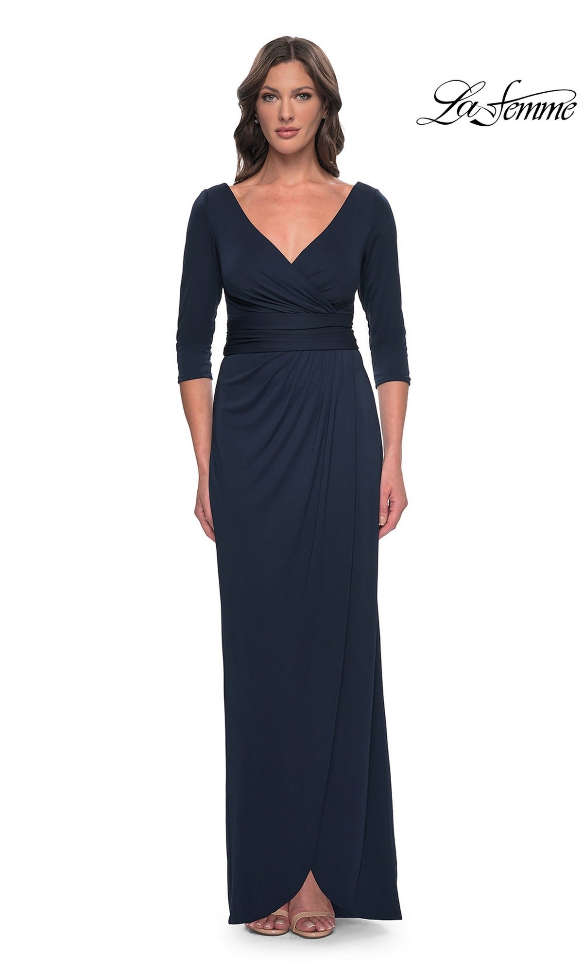 A woman wears a navy Long Formal Dress: La Femme 31014, featuring a long-sleeved, faux wrap design with a V-neckline and a modest formal silhouette.